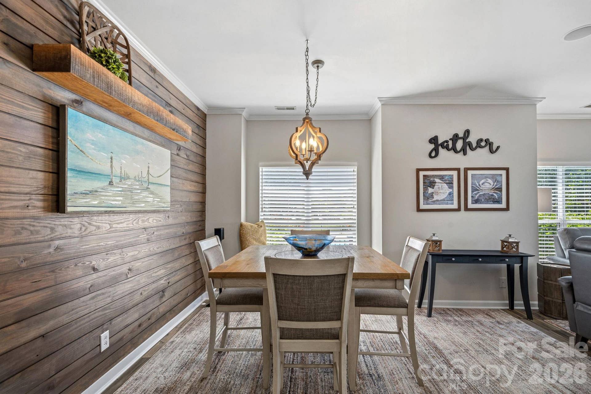 Opposite the kitchen, the dining area features a nautical-inspired shiplap accent wall and offers relaxing water views.