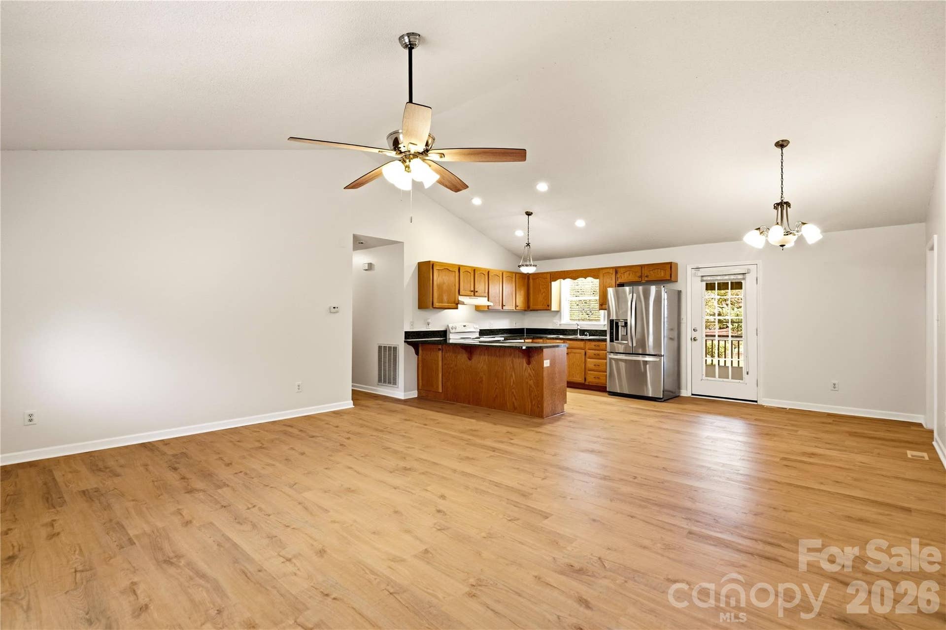 3892 Stoney Creek Drive, Lincolnton, NC 28092 Open-concept living room with vaulted ceilings and seamless flow into the kitchen and dining area.