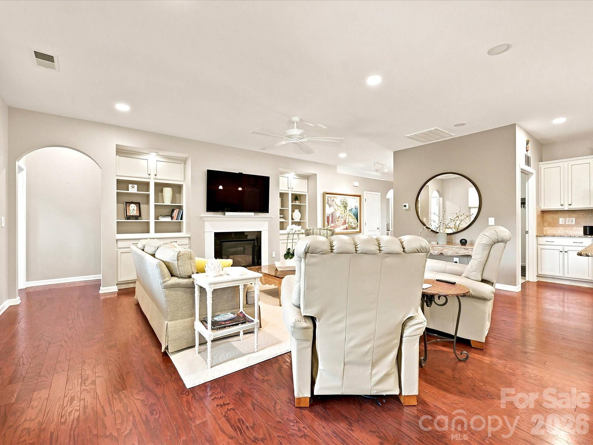 Great room with curved archway to primary bedroom