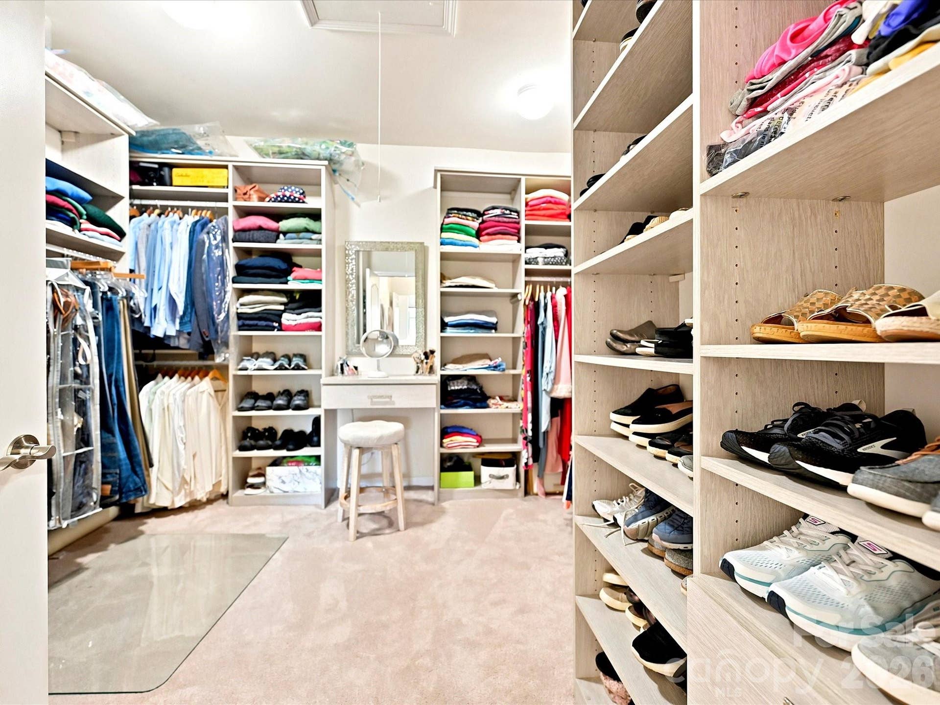 Amazing master closet with custom shelving plus vanity