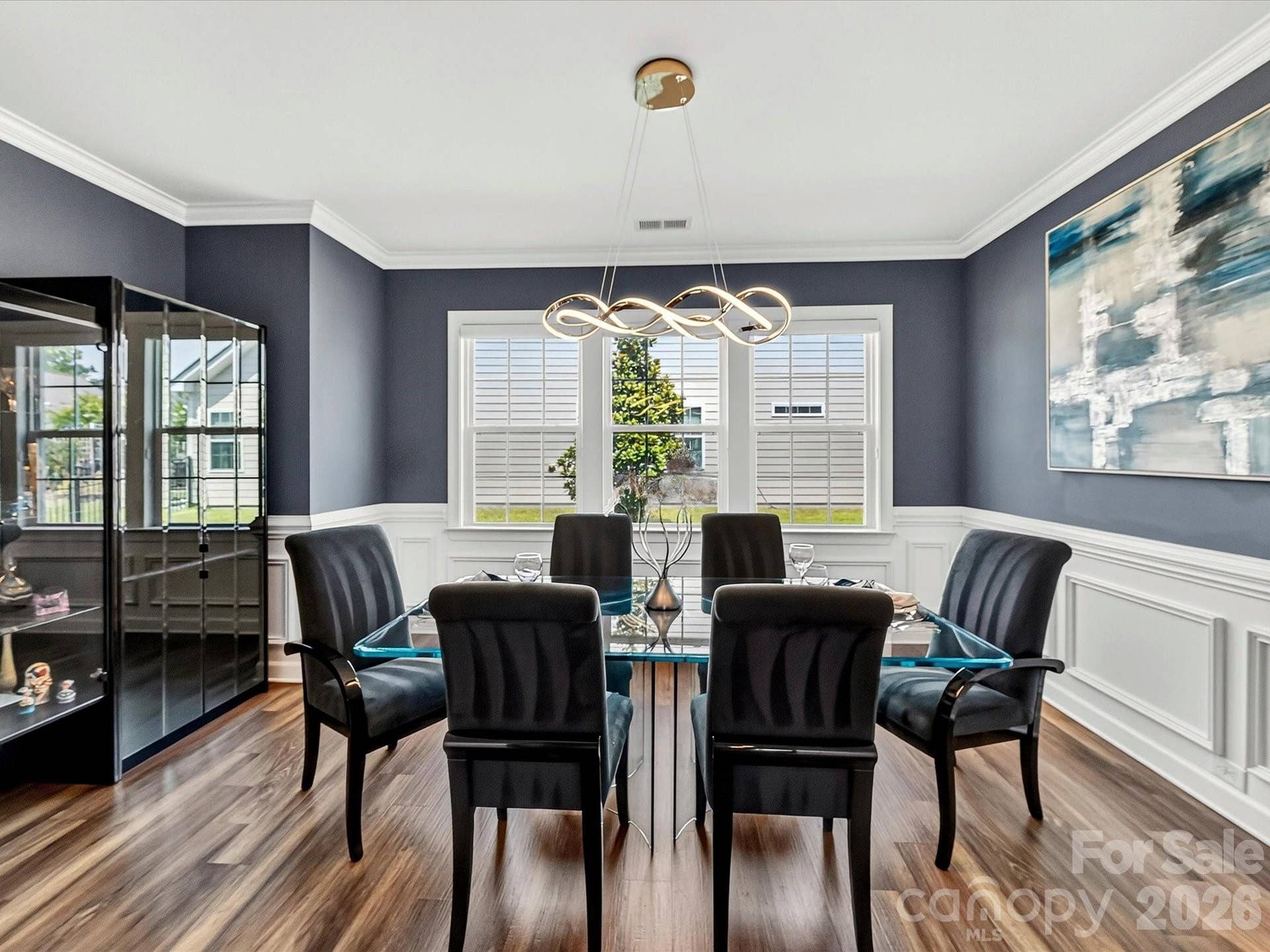 Dining Room Boasts of Modern Light Fixture, LVP Flooring, Crown, Chair and Picture Frame Moldings