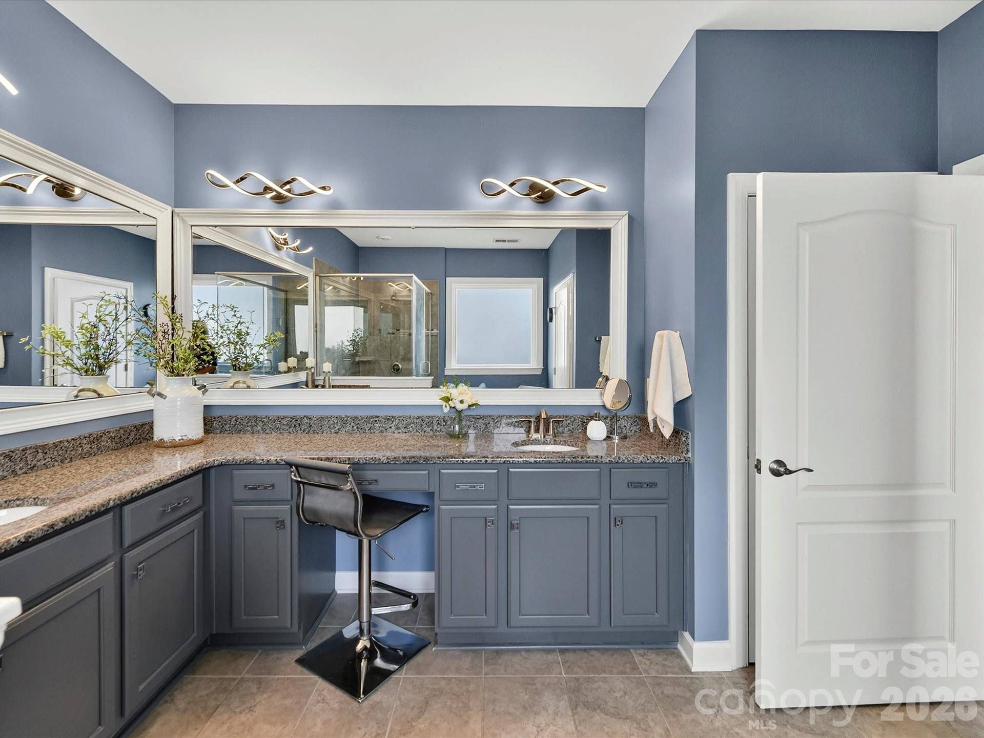 Primary Bath with Framed Mirrors, Granite Counters and Modern Light Fixtures