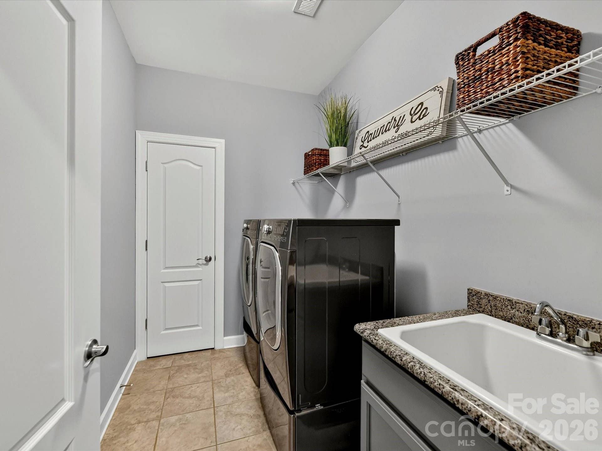 Separate Laundry Room with Closet, Tiled Flooring, Utility Sink and Cabinet with Granite Counter