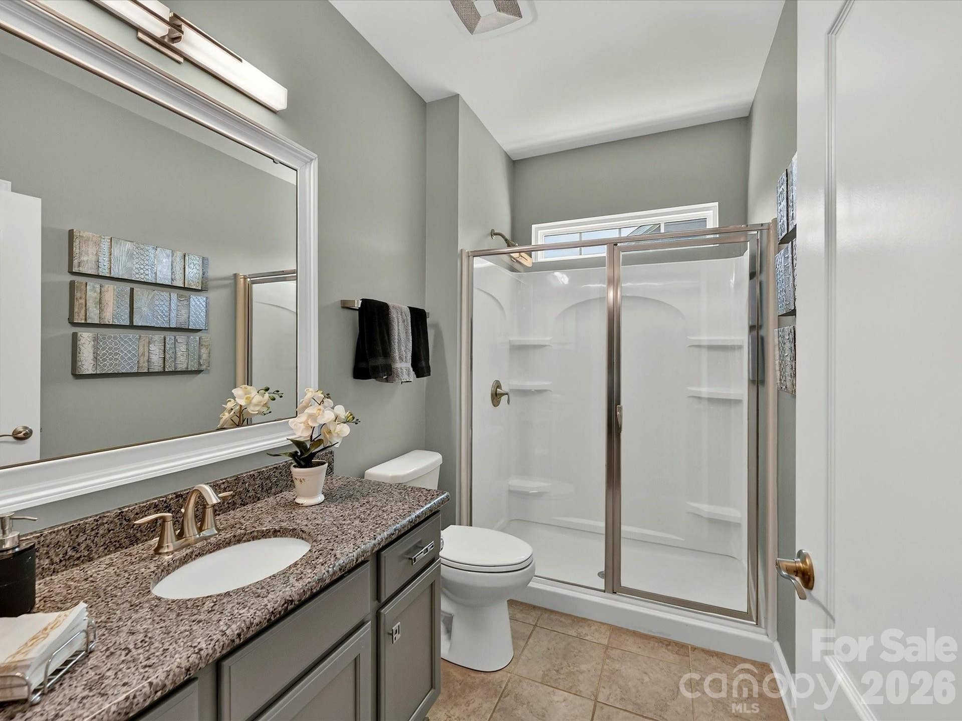 Full Guest Bath on Main with Granite Counters, Framed Mirror, Linen Closet and Tiled Flooring. Upgraded Light Fixture