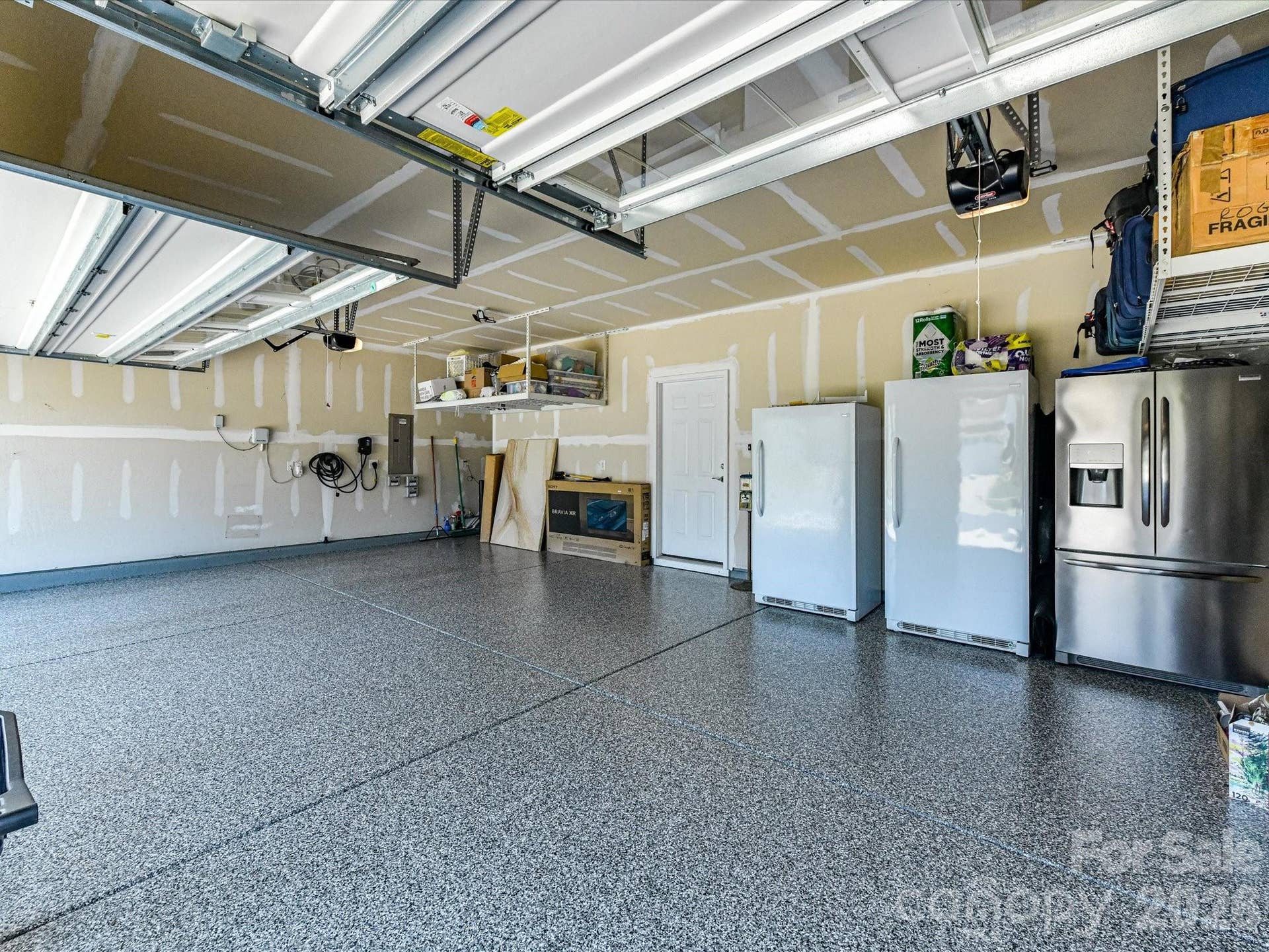 Three Car Garage with Epoxy Flooring, 240 Volt Outlet for Electric Car Charger, Tankless Water Heater, and Storage Lofts