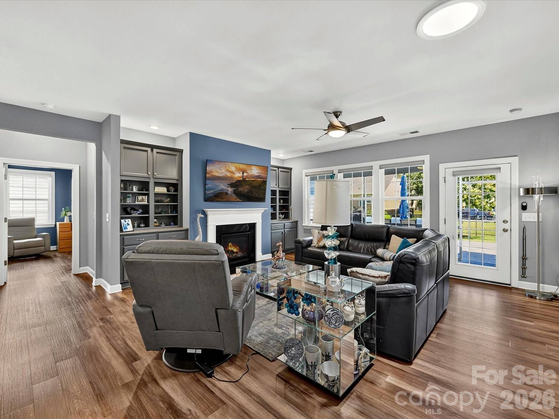 Spacious Great Room with Fan, LVP Flooring, and Built-in Cabinets