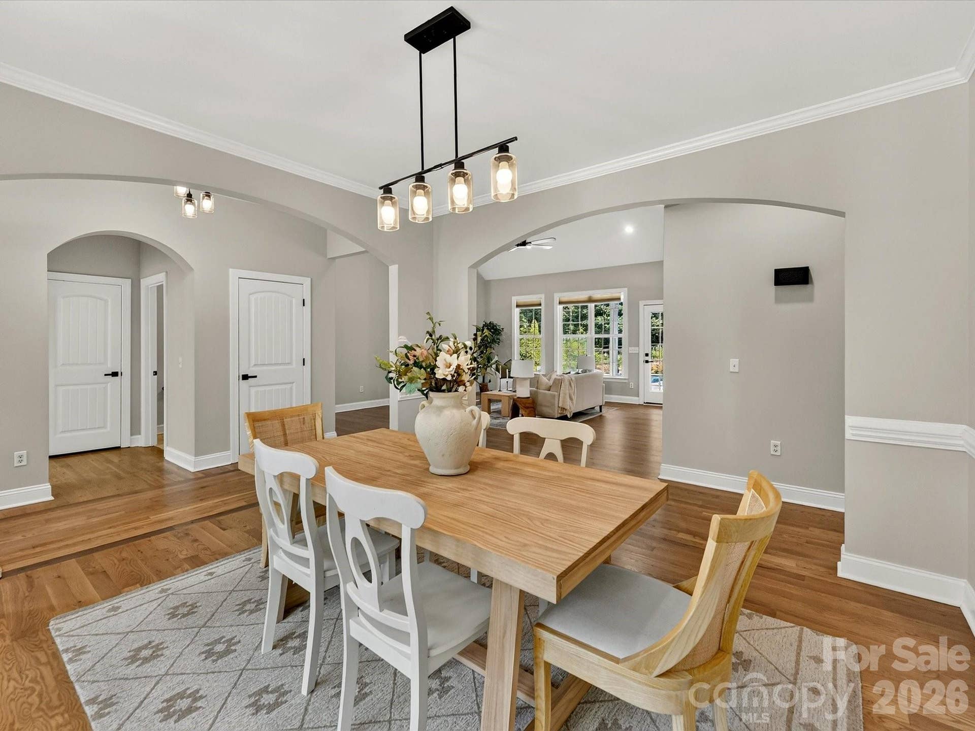 The beautiful dining room features wood floors, refined crown molding, and an open design that flows seamlessly into the main living areas for effortless entertaining.