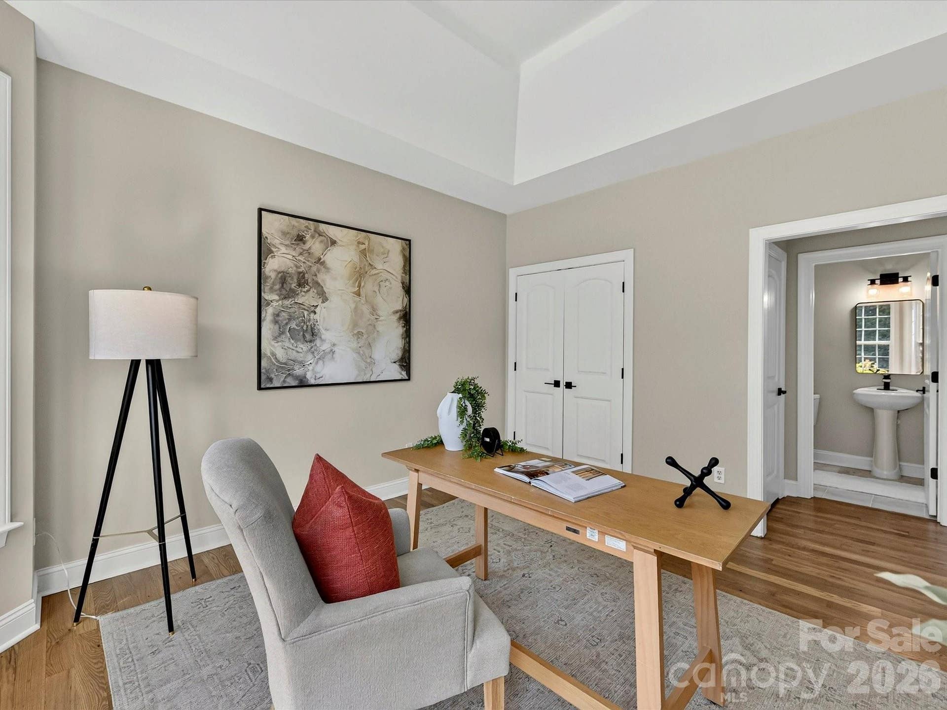 The versatile office with a tray ceiling, abundant natural light, and an adjacent powder room provides an ideal space for working from home or creating a private flex room.