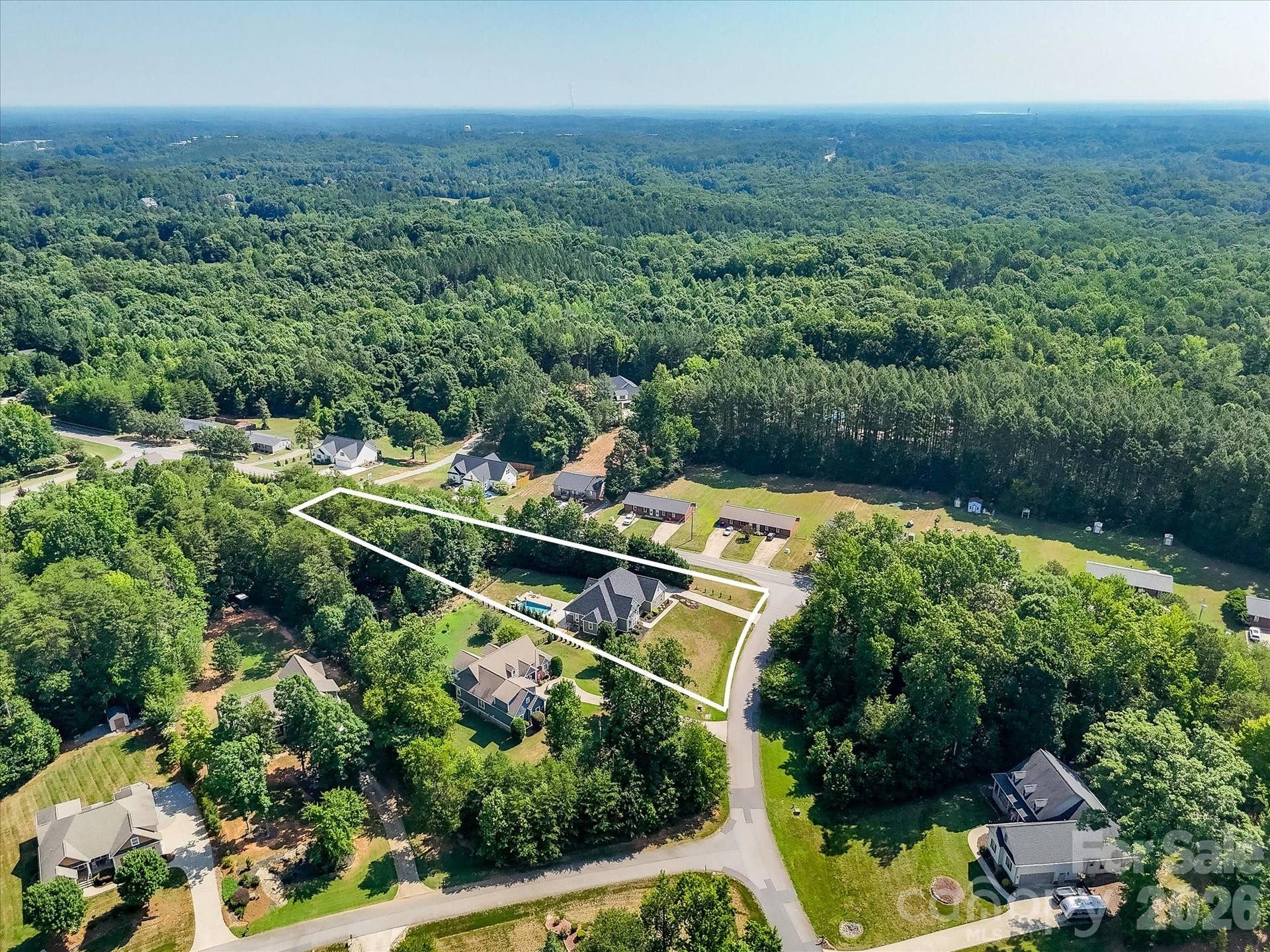 The aerial view with property lines (boundary lines are approximate) highlights the expansive homesite, exceptional privacy, and wooded surroundings while showcasing the home's spacious lot and prime location.