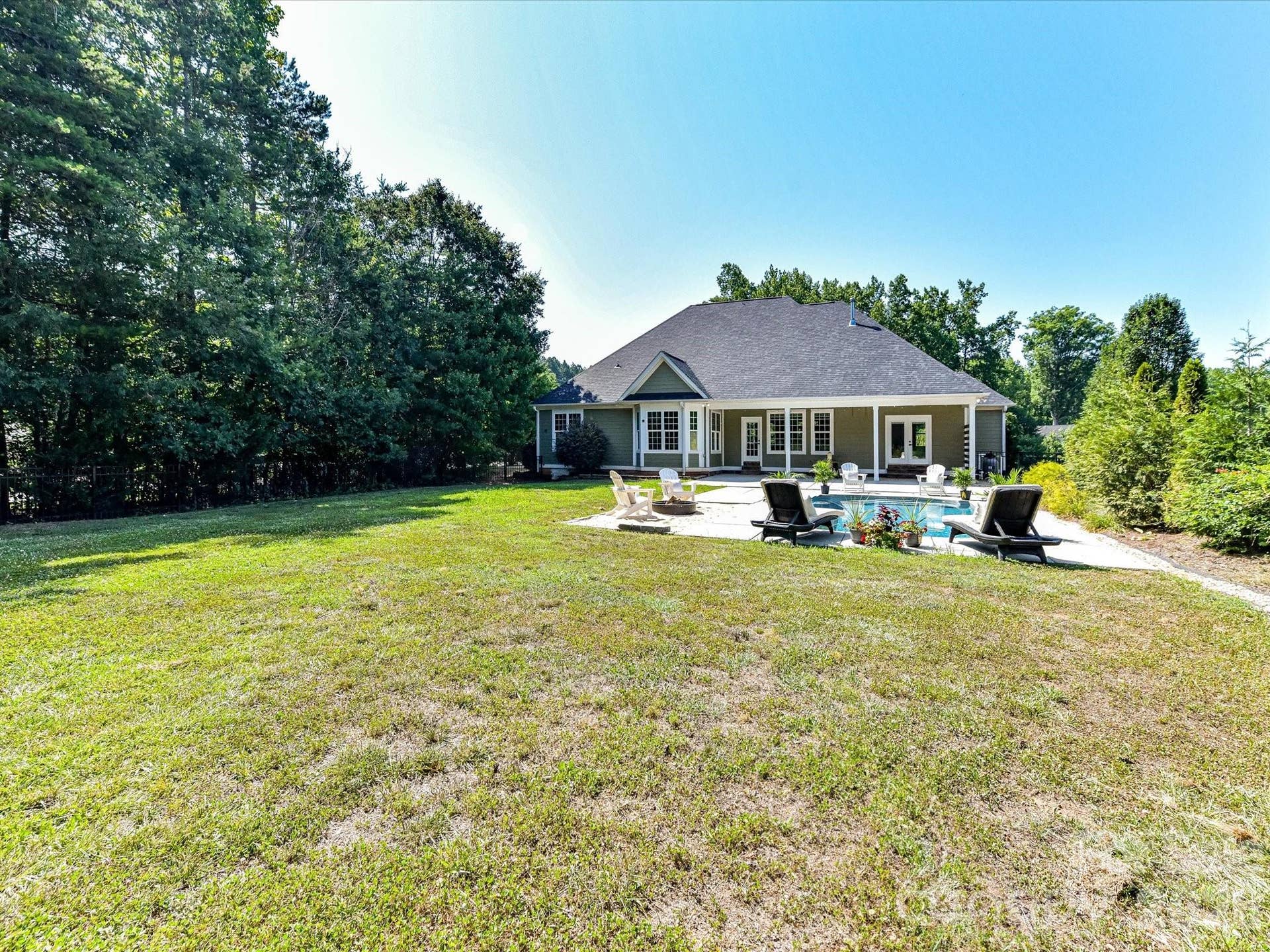 The huge, private backyard offers a large, level lawn, sparkling pool, and covered patio, creating the perfect setting for outdoor entertaining, recreation, and relaxation.