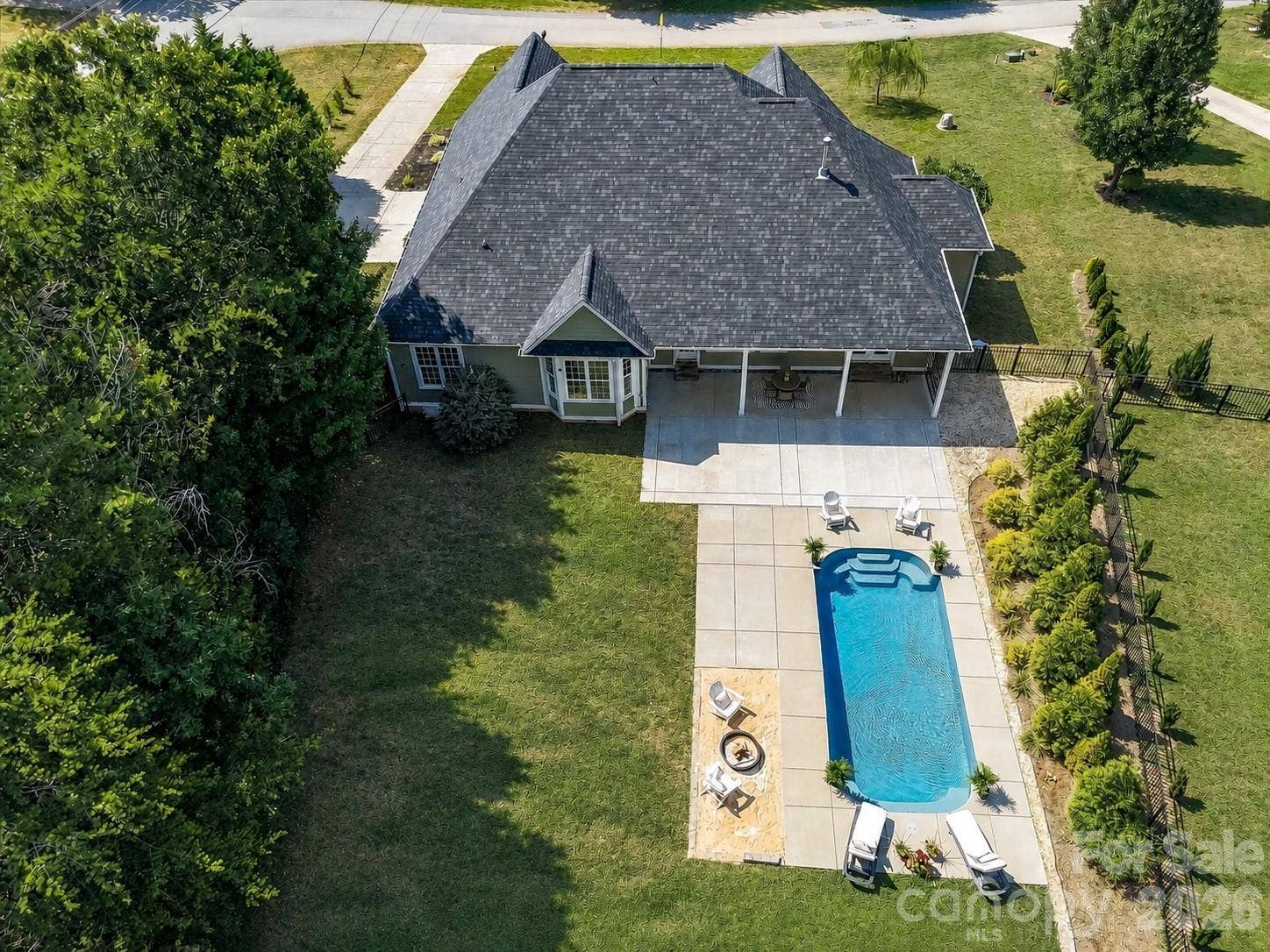 Resort-style outdoor living awaits with a sparkling in-ground pool, expansive patio, covered porch, and a private backyard designed for relaxing and entertaining.