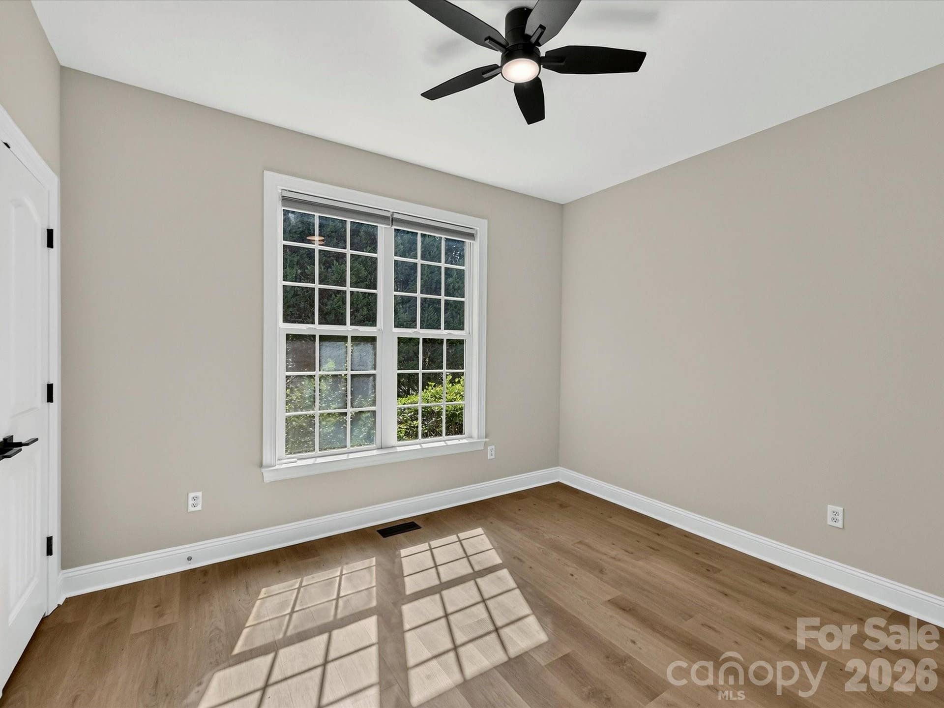 Bedroom 3 offers abundant natural light, luxury vinyl plank flooring, a ceiling fan, and generous closet space, creating a comfortable retreat for family or guests.