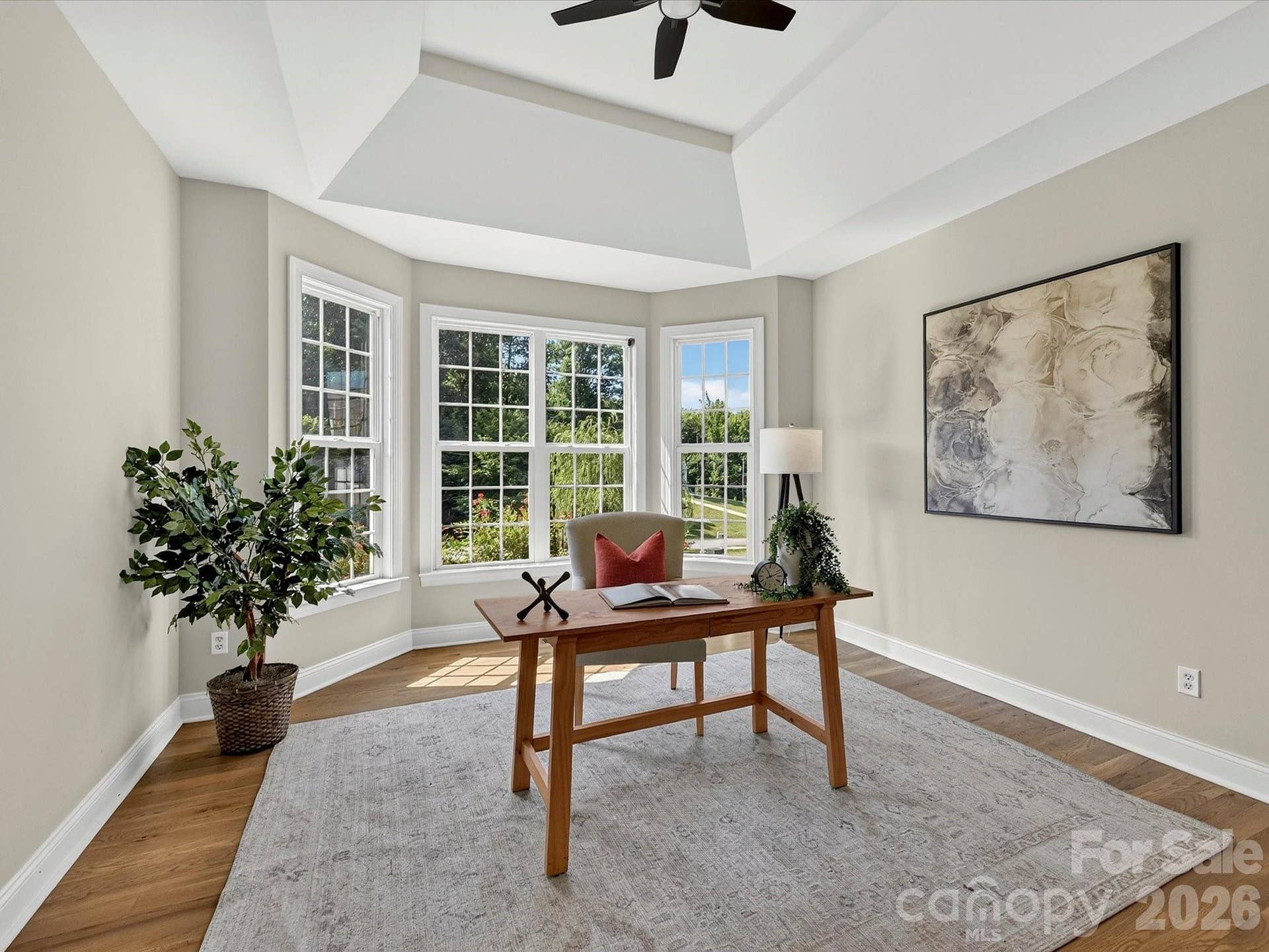 The versatile office with a tray ceiling, abundant natural light, and an adjacent powder room provides an ideal space for working from home or creating a private flex room.