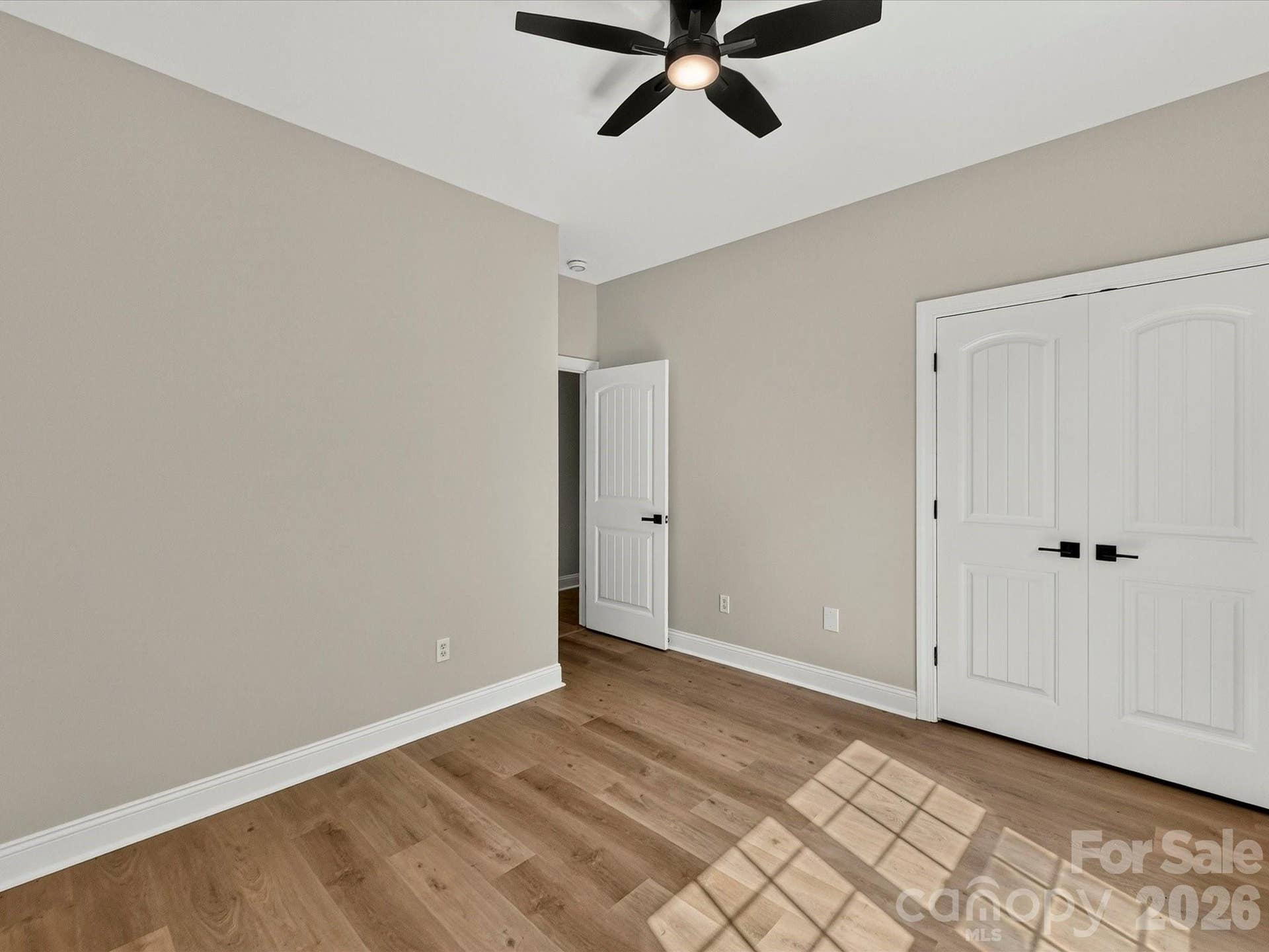 Bedroom 3 offers abundant natural light, luxury vinyl plank flooring, a ceiling fan, and generous closet space, creating a comfortable retreat for family or guests.