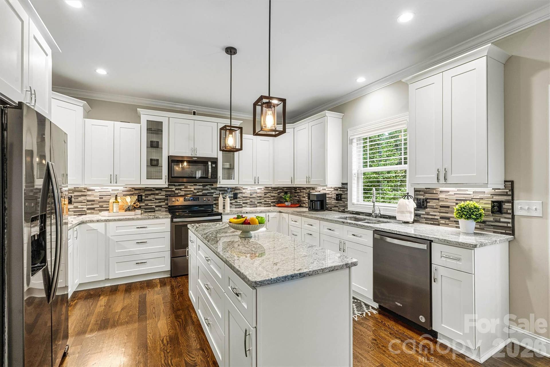 Kitchen has granite island and countertops, updated lighting and plenty of cabnetry for all your cooking needs