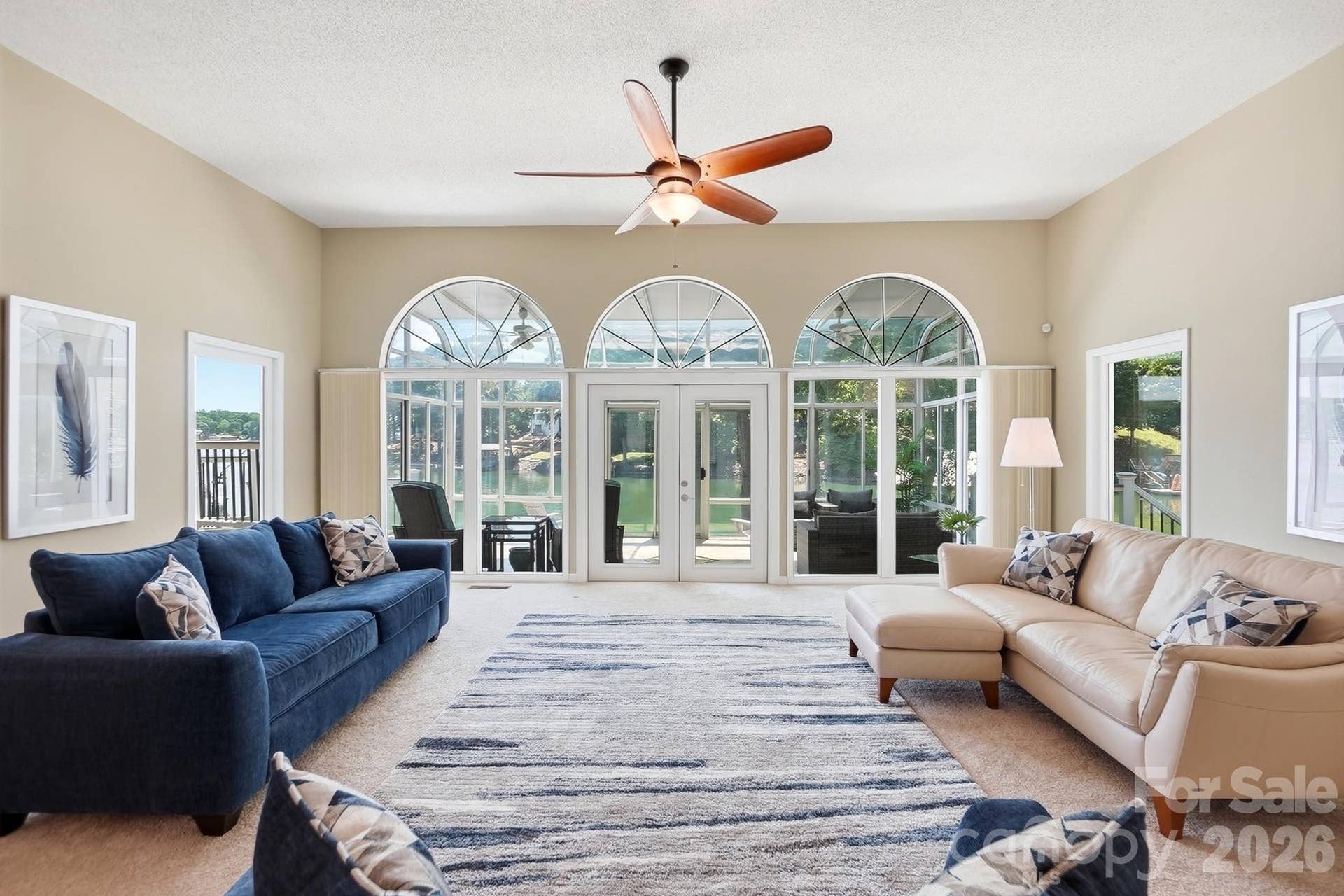 Great room with dramatic arched windows showcasing breathtaking lake views