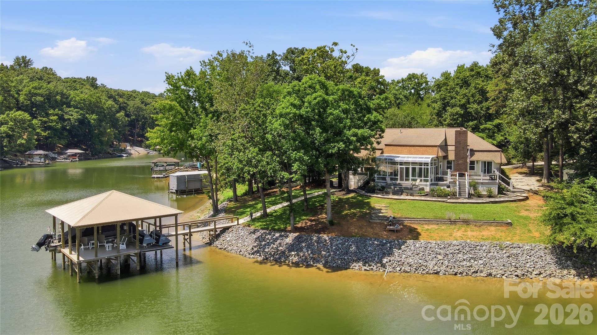Sprawling waterfront ranch perfectly positioned on  hard-to-find level lot totaling approximately 0.75 acres in desirable Tega Cay