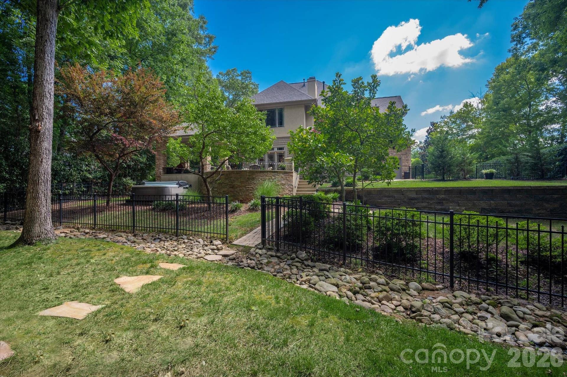 Fenced backyard area with diverse yard usage areas for entertaining flexibility.