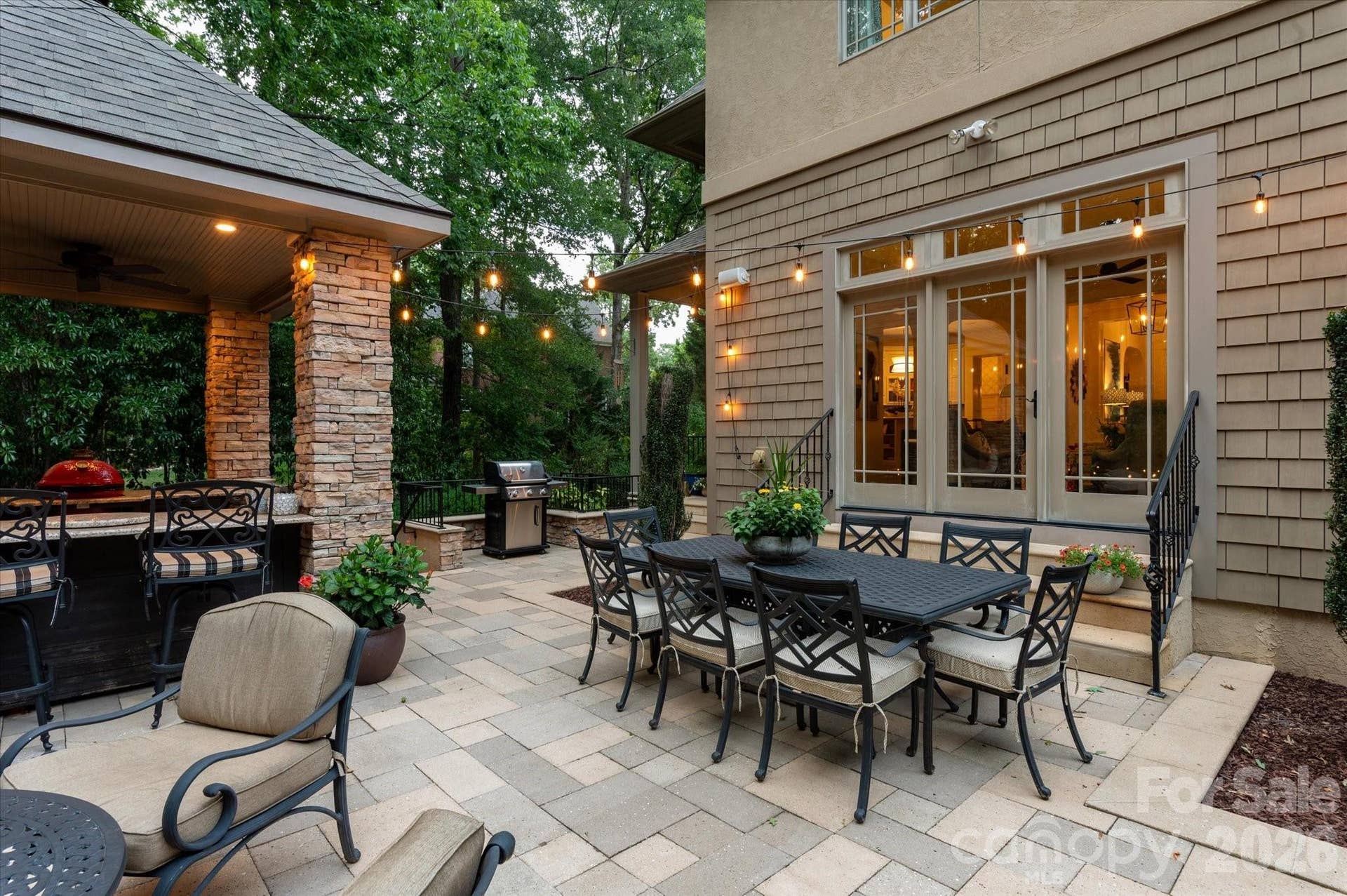 An enchanting evening escape where professional hardscaping meets the beauty of the surrounding forest canopy...