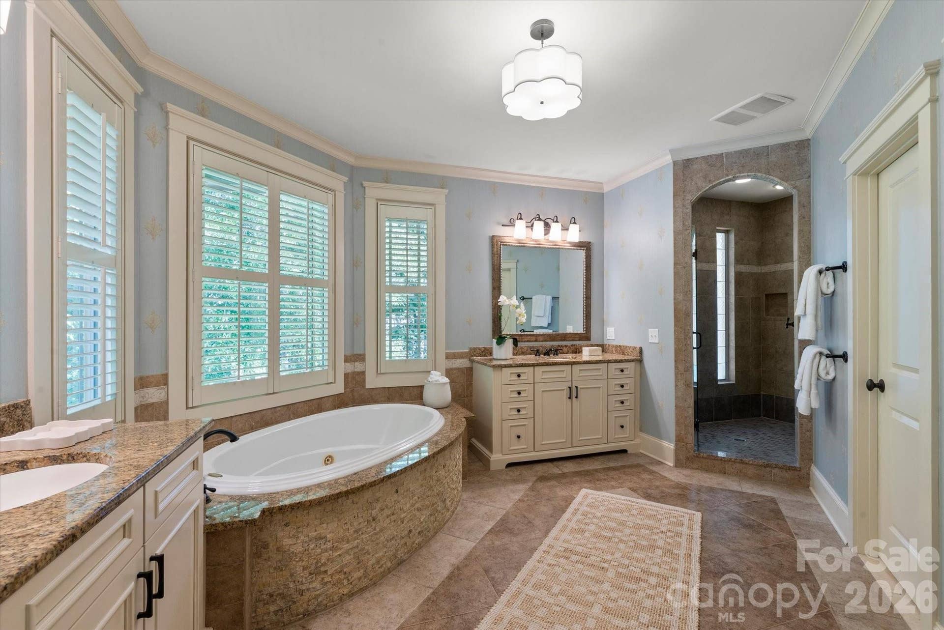 A spa-like escape complete with a deep jetted soaking tub, frameless glass shower, and dual custom vanities.