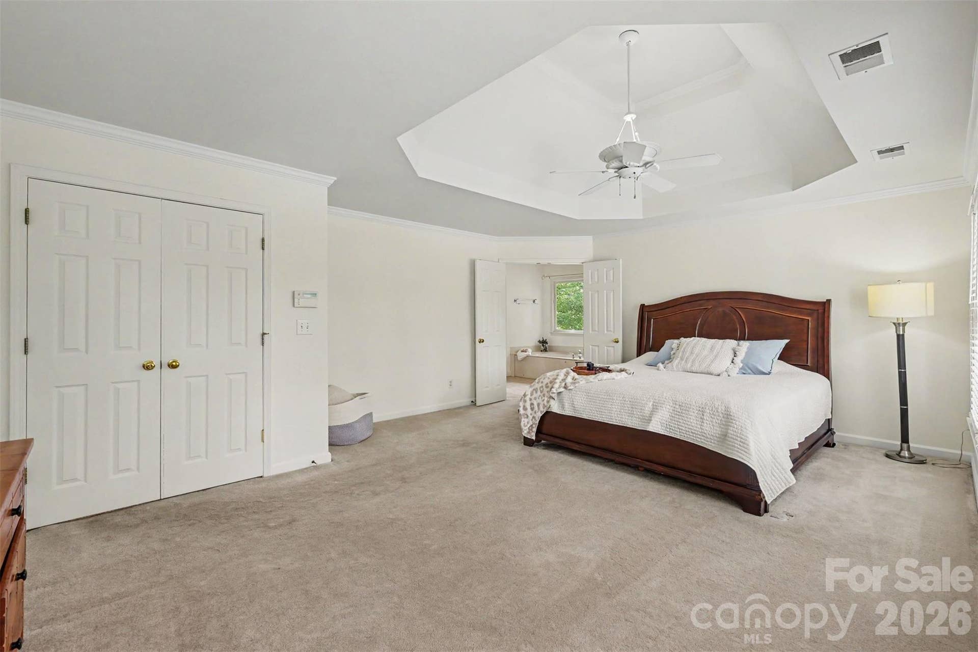 Double doors lead to the Primary bedroom with deep trey ceiling