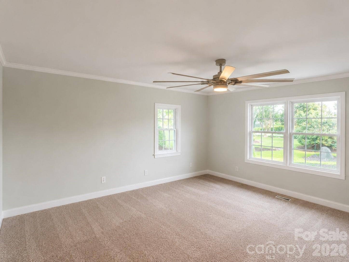 Primary bedroom with ample light and ceiling fan