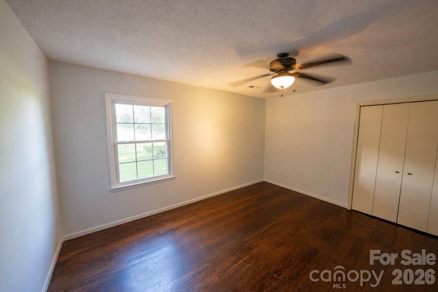 Second floor guest bedroom with wall closet and ceiling fan