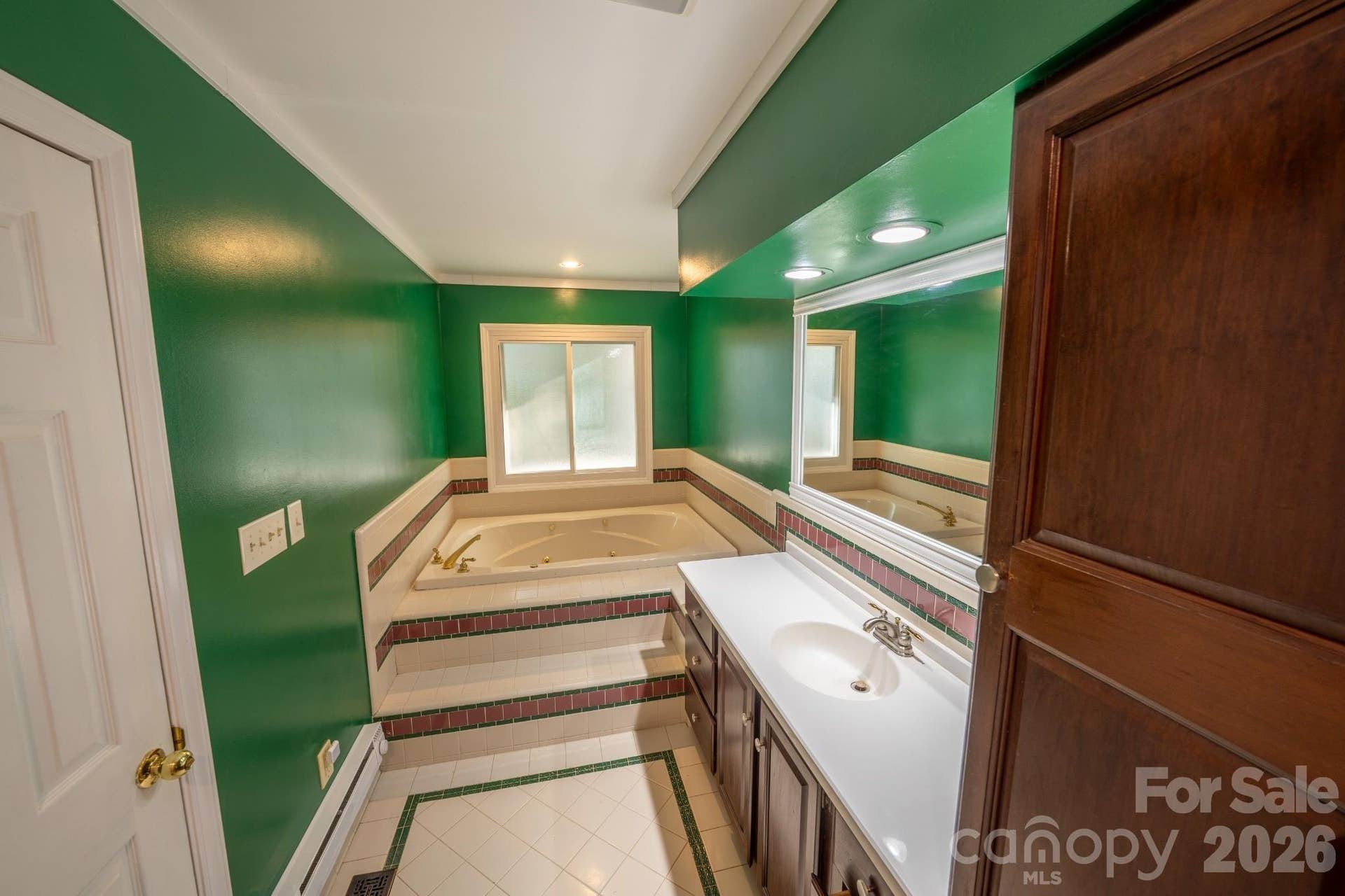 En-suite primary bath w/ tub and tile flooring