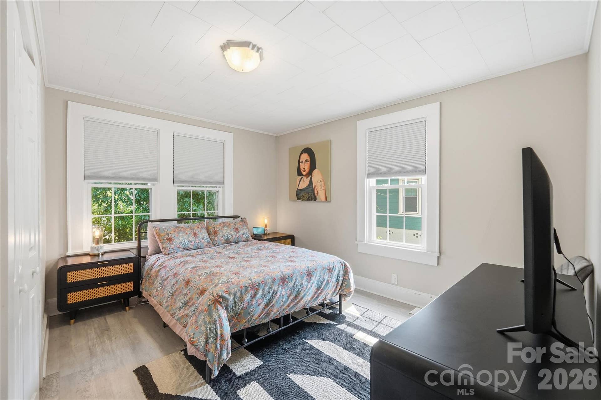 Tucked at the back of the home, this bedroom features large windows overlooking the backyard, filling the space with natural light throughout the day.