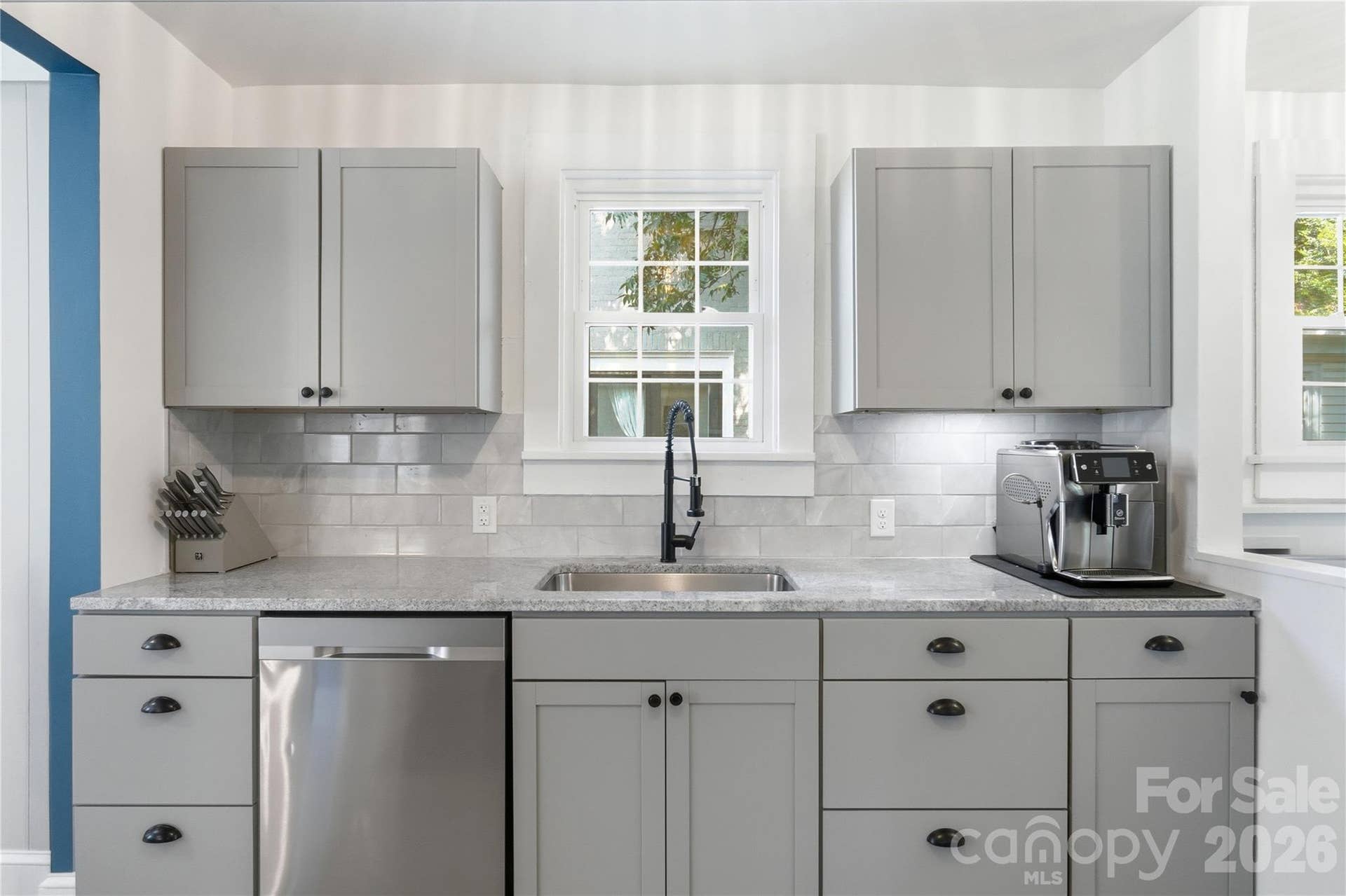A stylish black gooseneck faucet, subway tile backsplash, and abundant cabinet storage make this kitchen as functional as it is beautiful.
