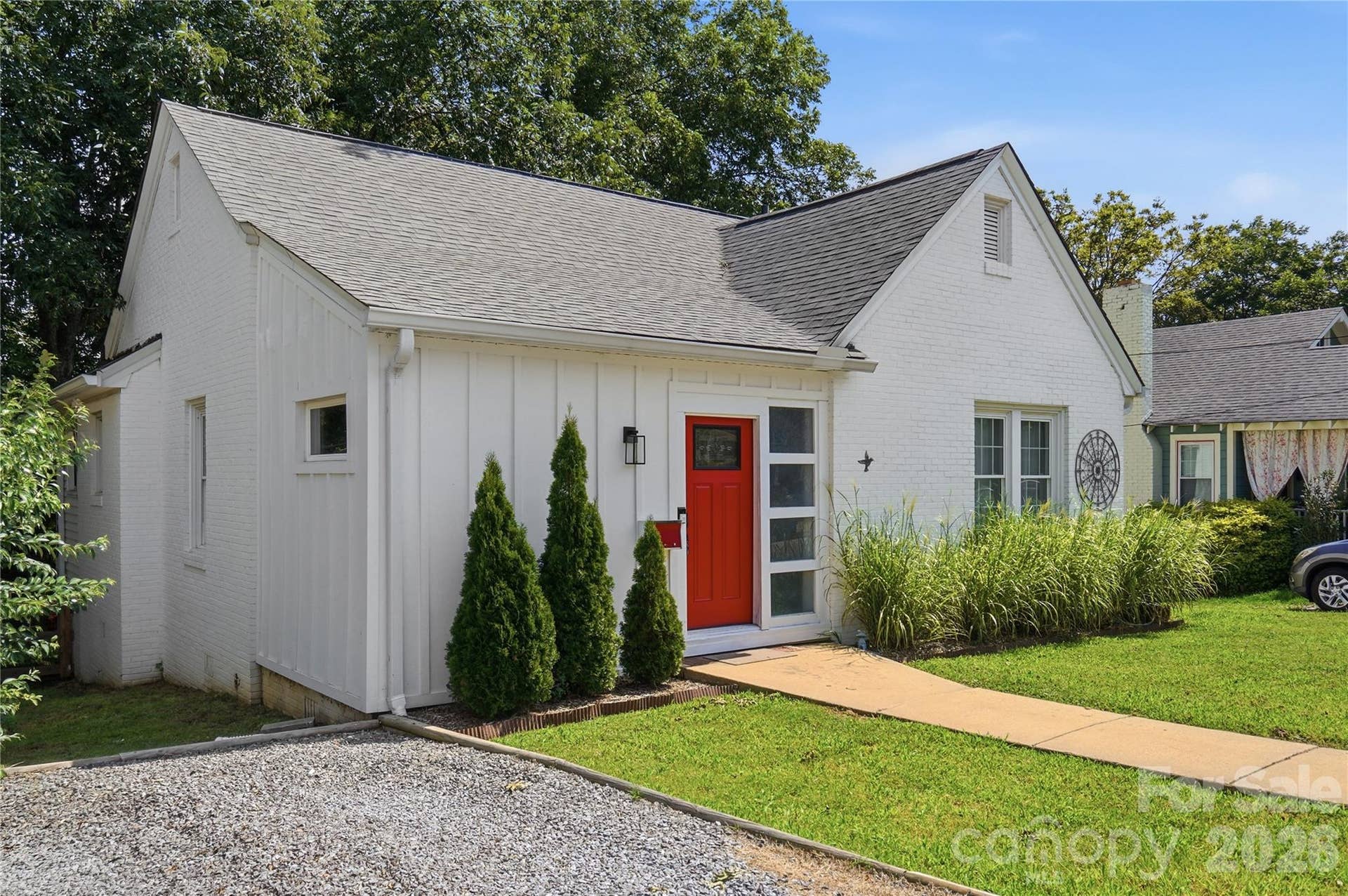 A gravel parking pad sits alongside the home, with easy access to the front entry.