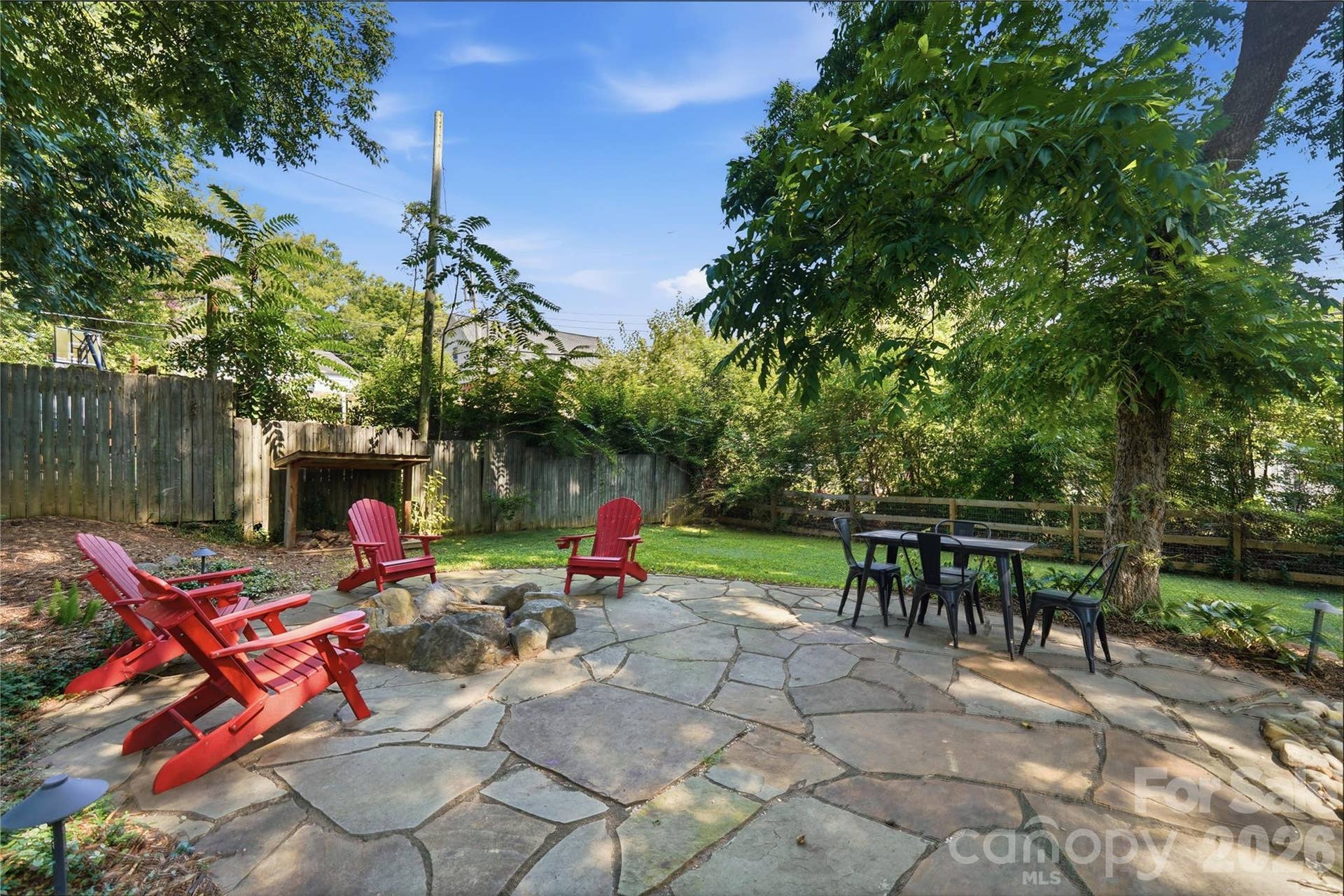 The flagstone patio offers multiple spaces to gather, from fireside seating to a separate area for outdoor dining.