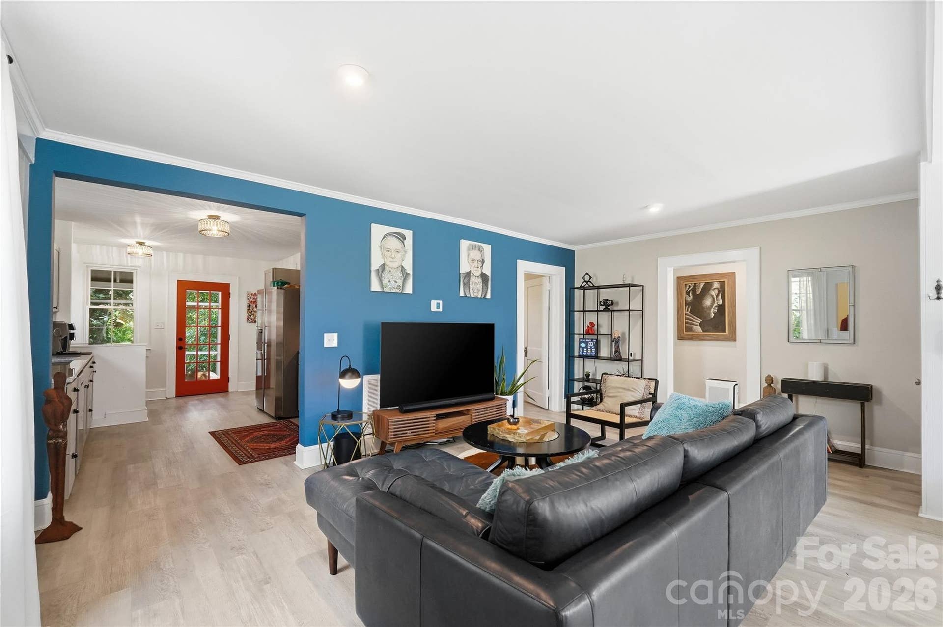A living room with personality. The bold feature wall adds character, while an open layout keeps the kitchen just steps away and the space easy to gather in.