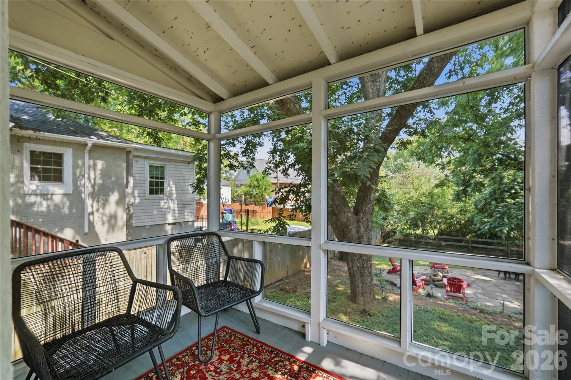 A screened porch off the kitchen offers a shaded spot to relax, with views straight out to the backyard below.