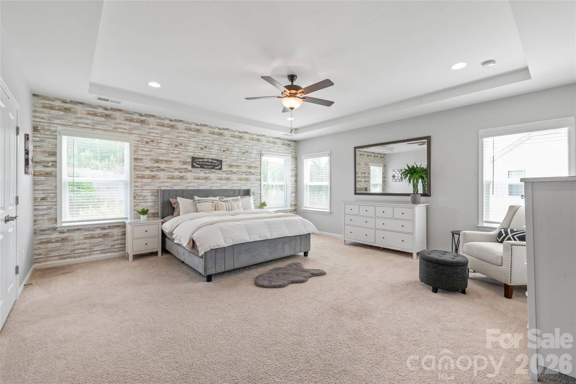 A serene private retreat, the spacious primary bedroom boasts elegant trey ceilings and a luxurious attached ensuite.
