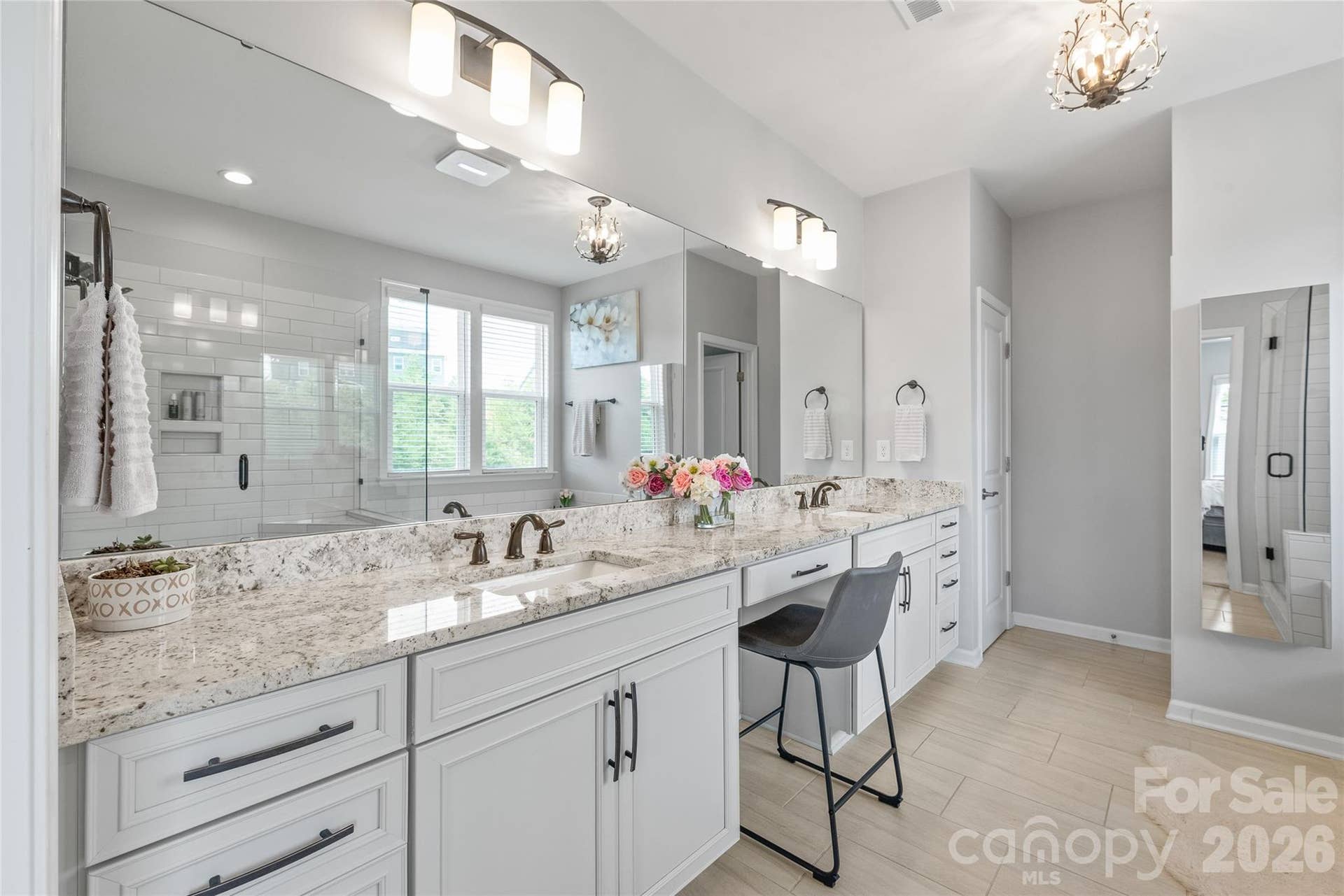 Dual vanities, sprawling countertops, and ample cabinetry make this primary ensuite as functional as it is beautiful.
