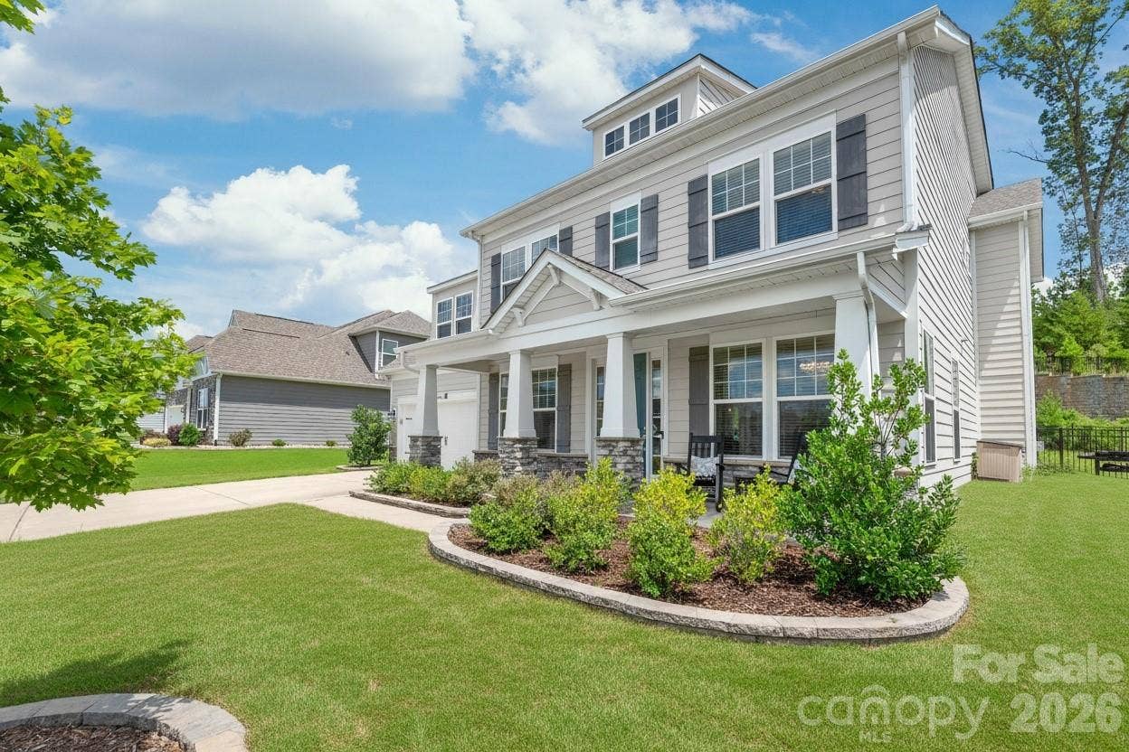 Crafted for lasting durability and timeless beauty, the exterior features low-maintenance cement siding anchored by striking stone accent columns.