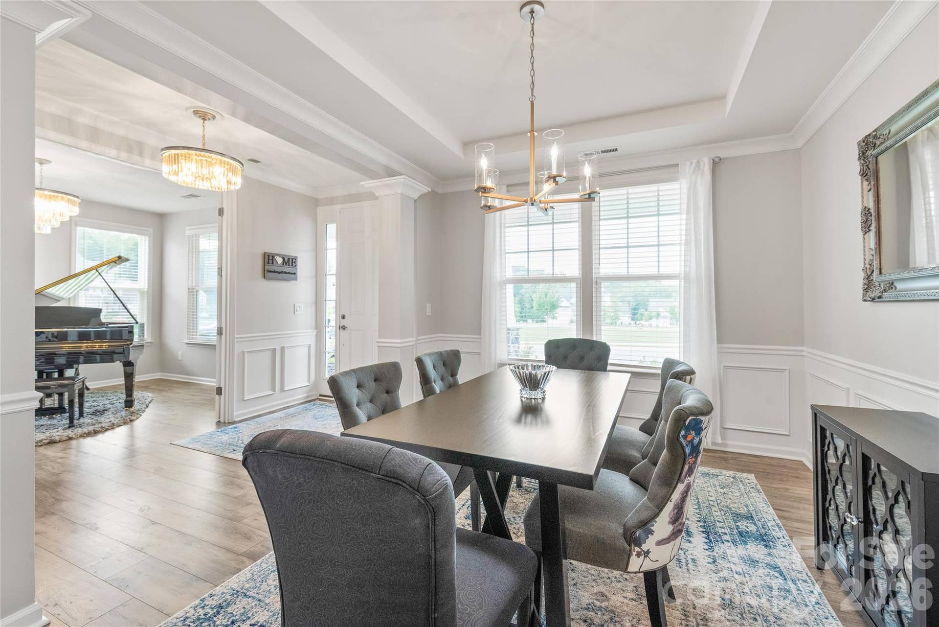 Across the hall, the elegant dining room features refined trey ceilings, detailed trimwork, and seamless LVP floors designed for memorable dinners and effortless hosting.