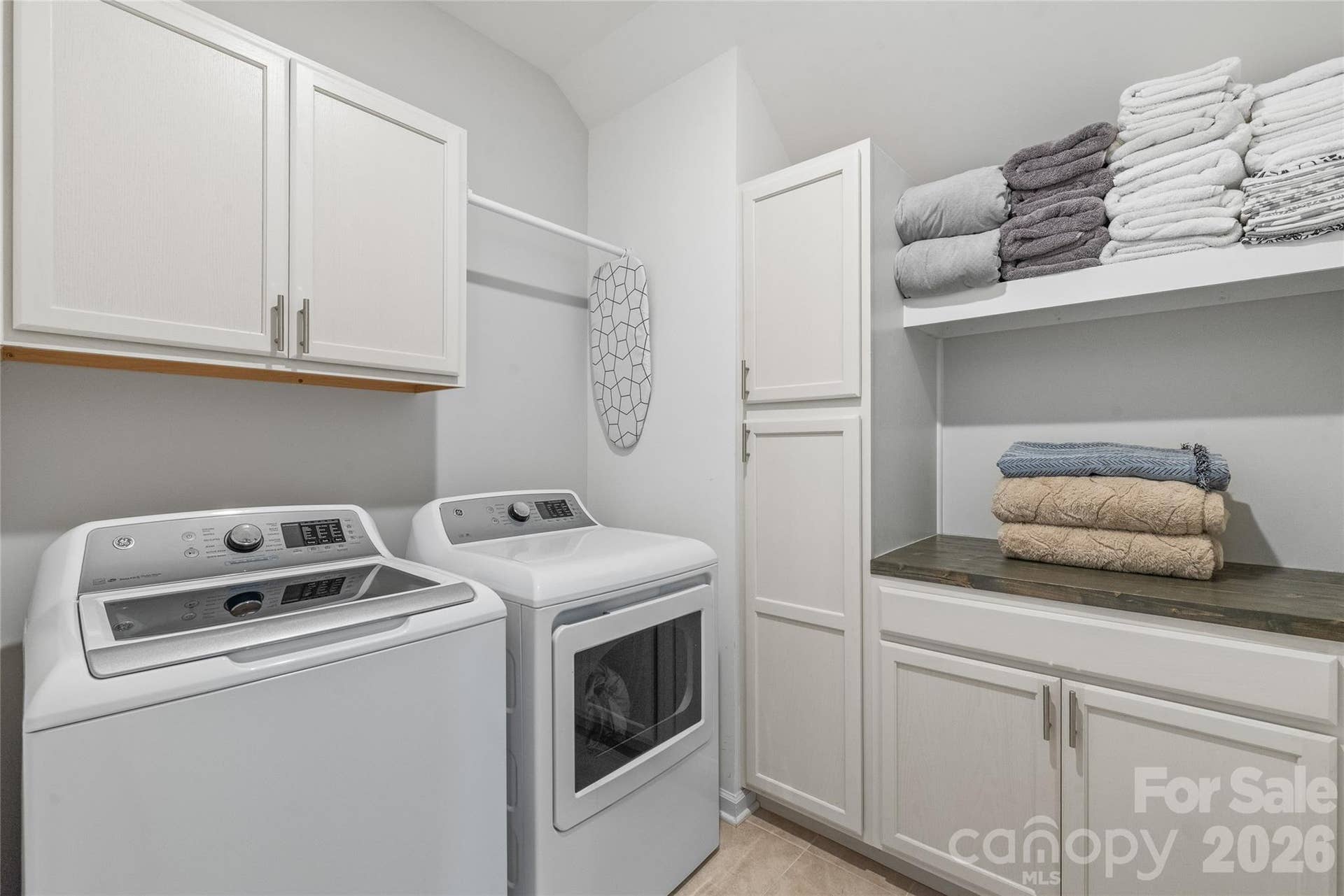 A dedicated laundry room equipped with custom built-in cabinets and continuous countertop space to make folding and sorting effortlessly organized.