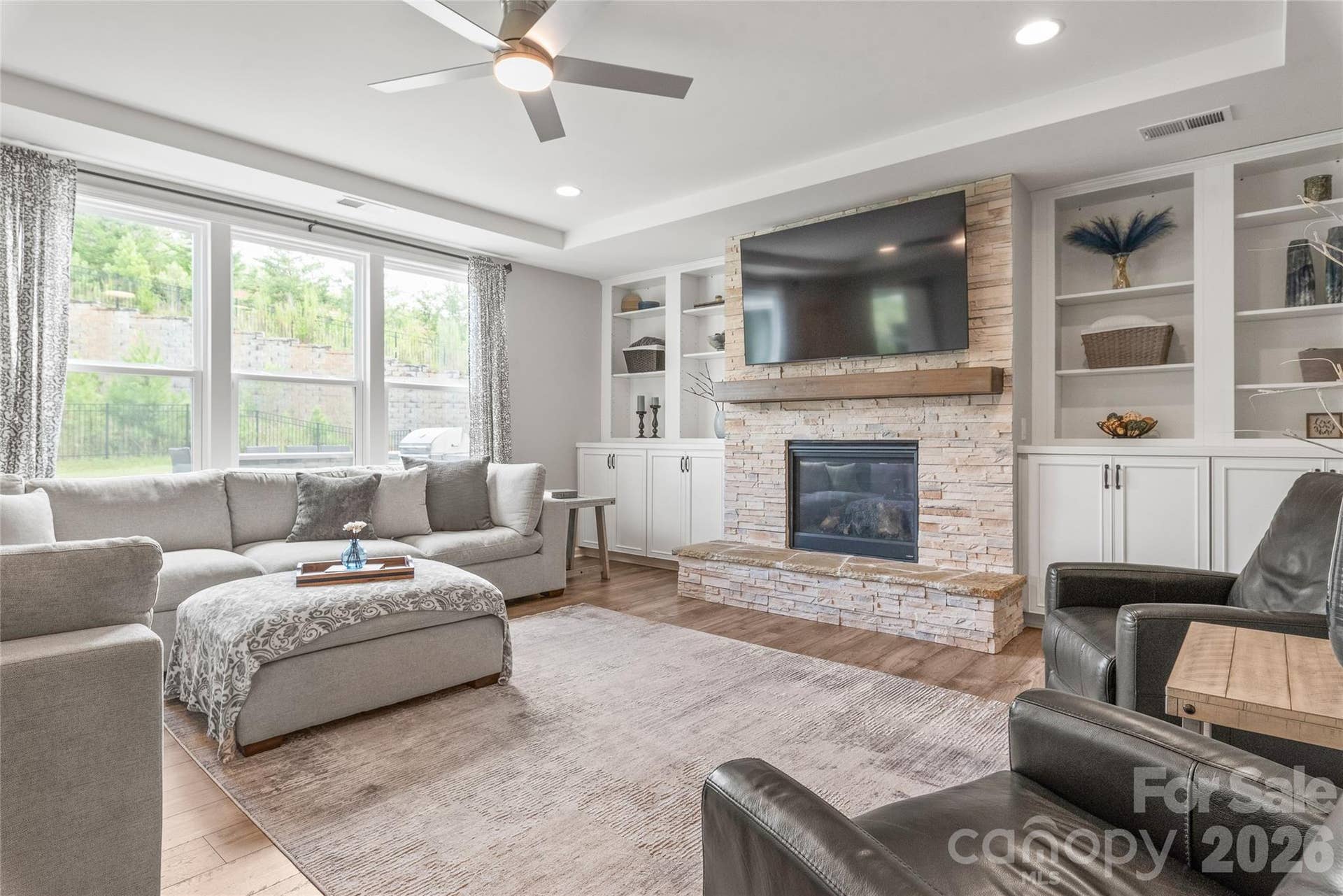 Flooded with natural light, the living room features expansive windows that highlight the beauty and continuity of the LVP floors.