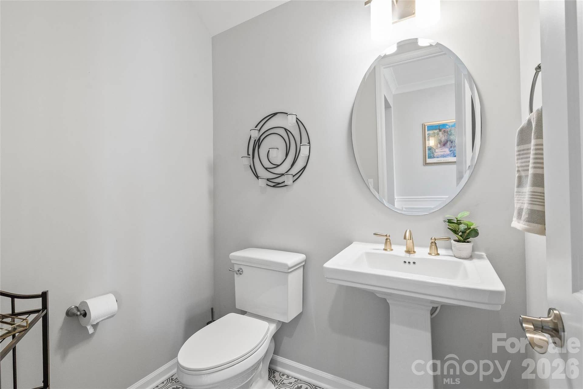 Tucked away for privacy, this main-level powder room features a classic pedestal sink ideal for guests.