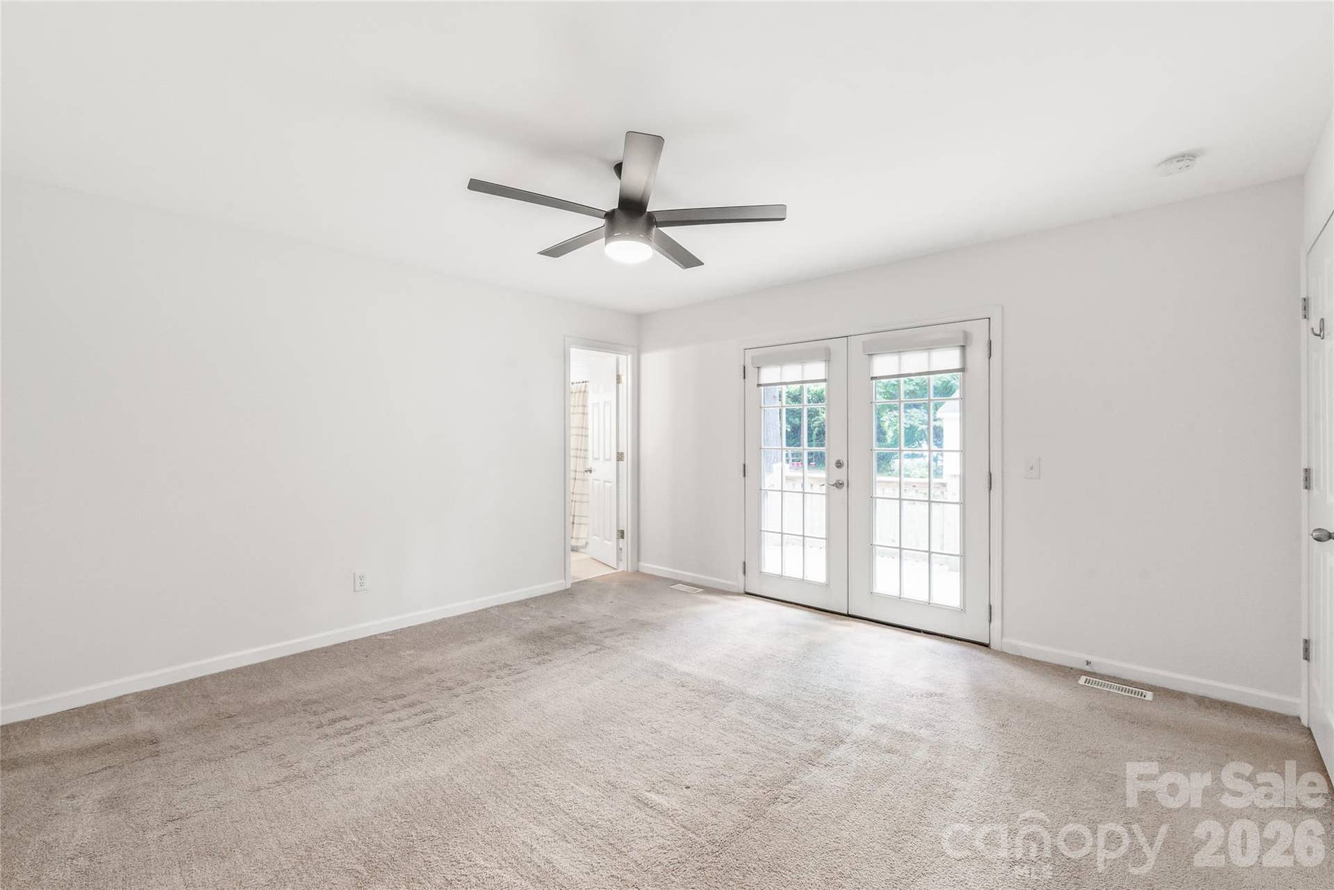Double doors in the primary bedroom offer direct access to the private back deck, enhancing natural light and indoor.
