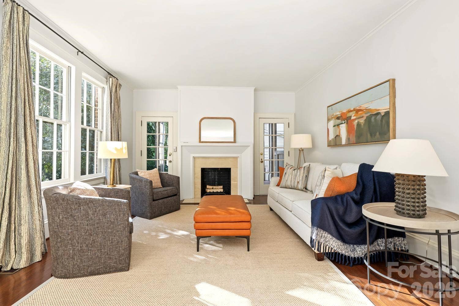 Light filled living room with modern updated fireplace and french door leading to a covered side porch