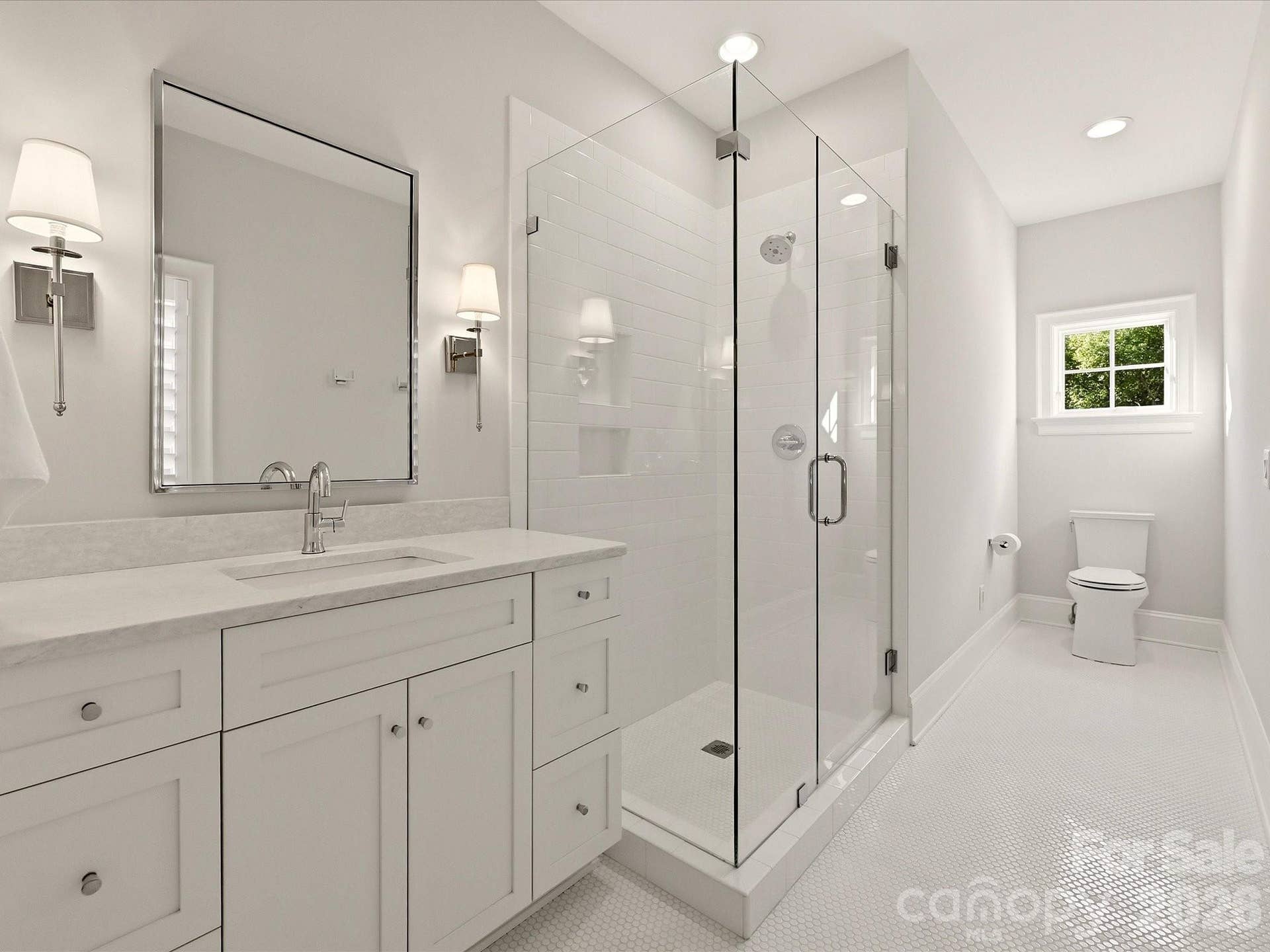 Bedroom 4 ensuite bath features a frameless glass shower, spacious vanity with stone countertop, crisp tile finishes, and abundant natural light.