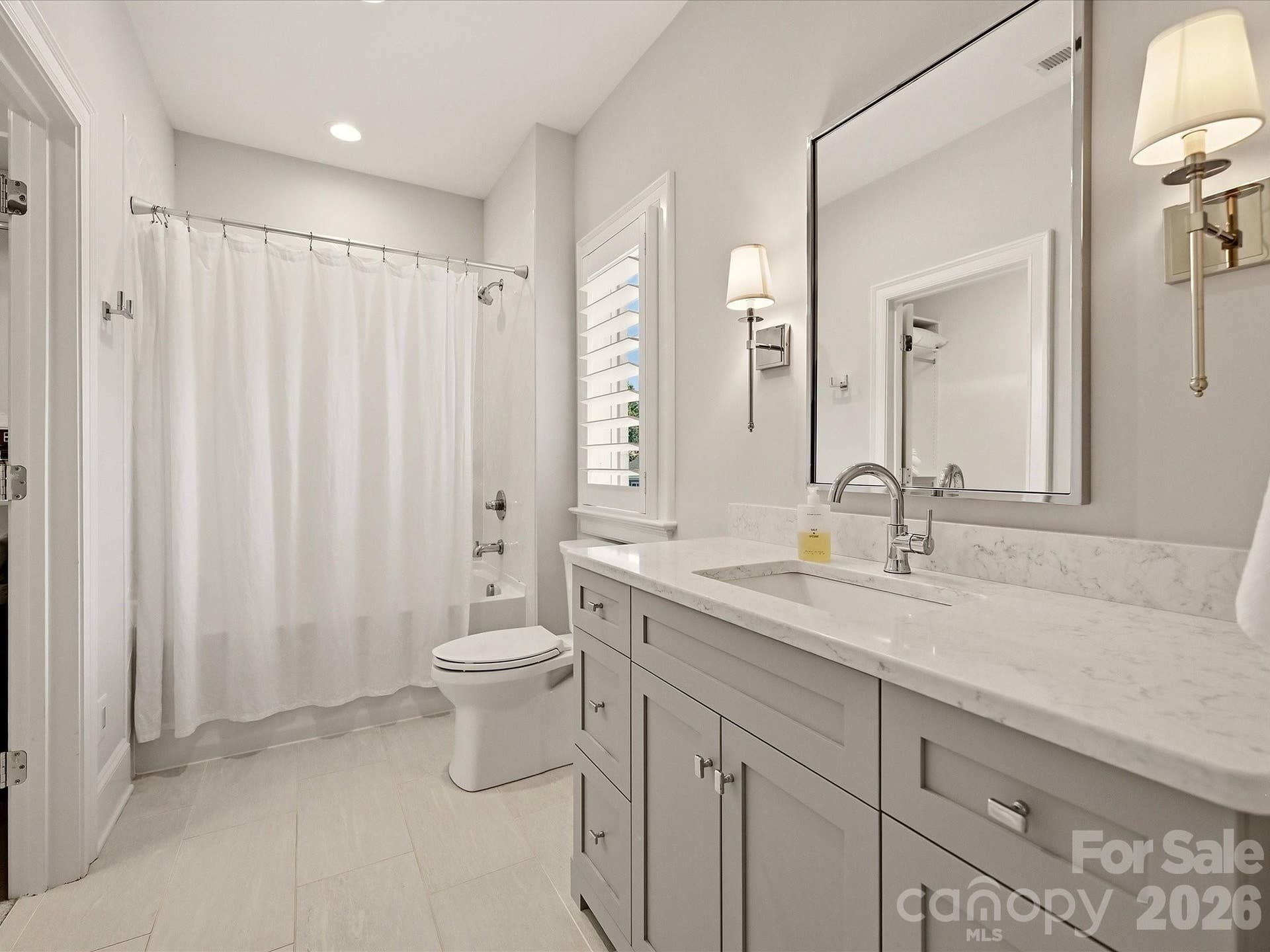 Bedroom 3 ensuite bath features a spacious vanity with stone countertop, tub/shower combination, modern finishes, and abundant natural light.