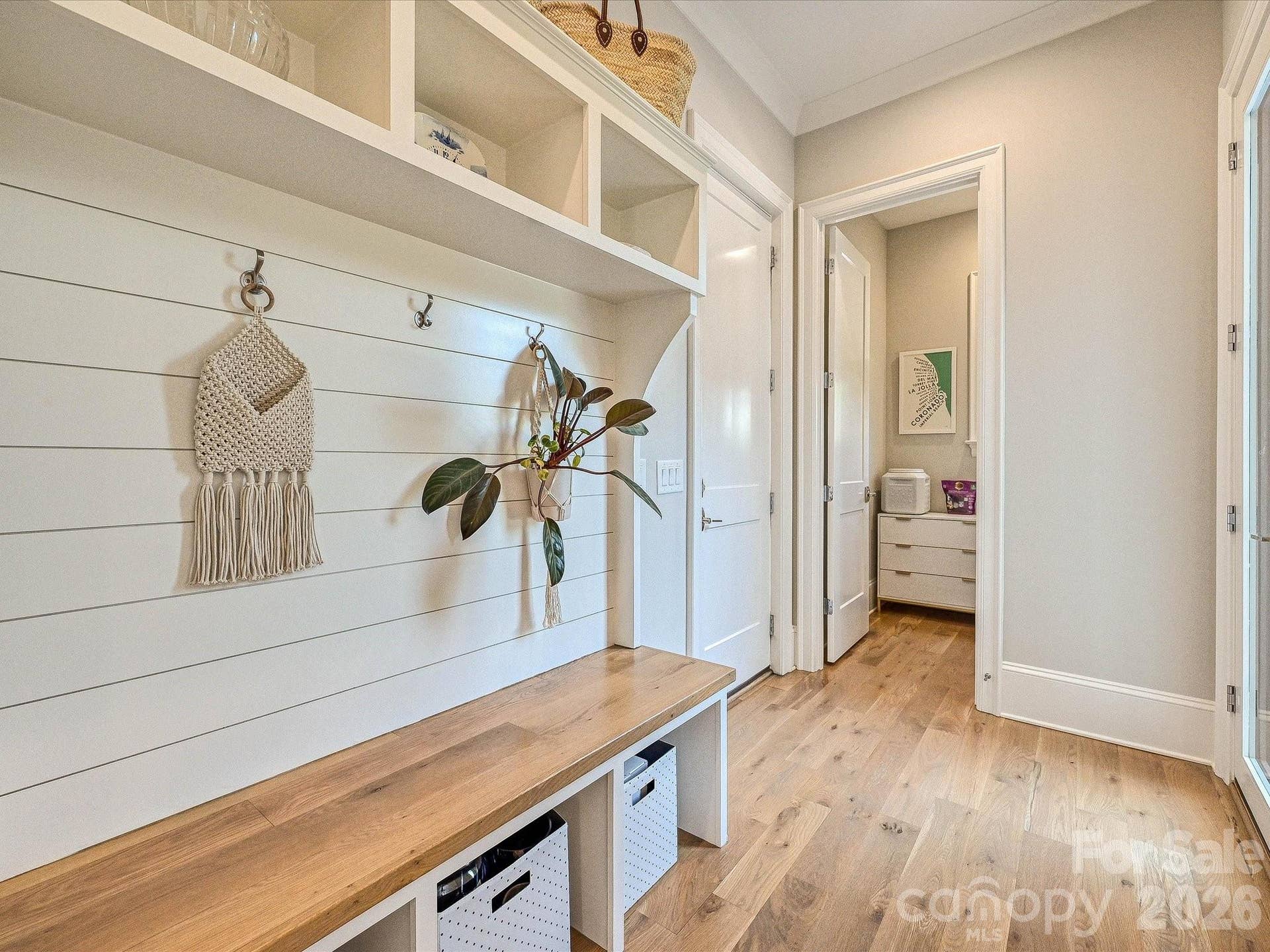 Functional drop zone features a built-in bench, open storage, and convenient hooks to keep everyday essentials organized and within easy reach.