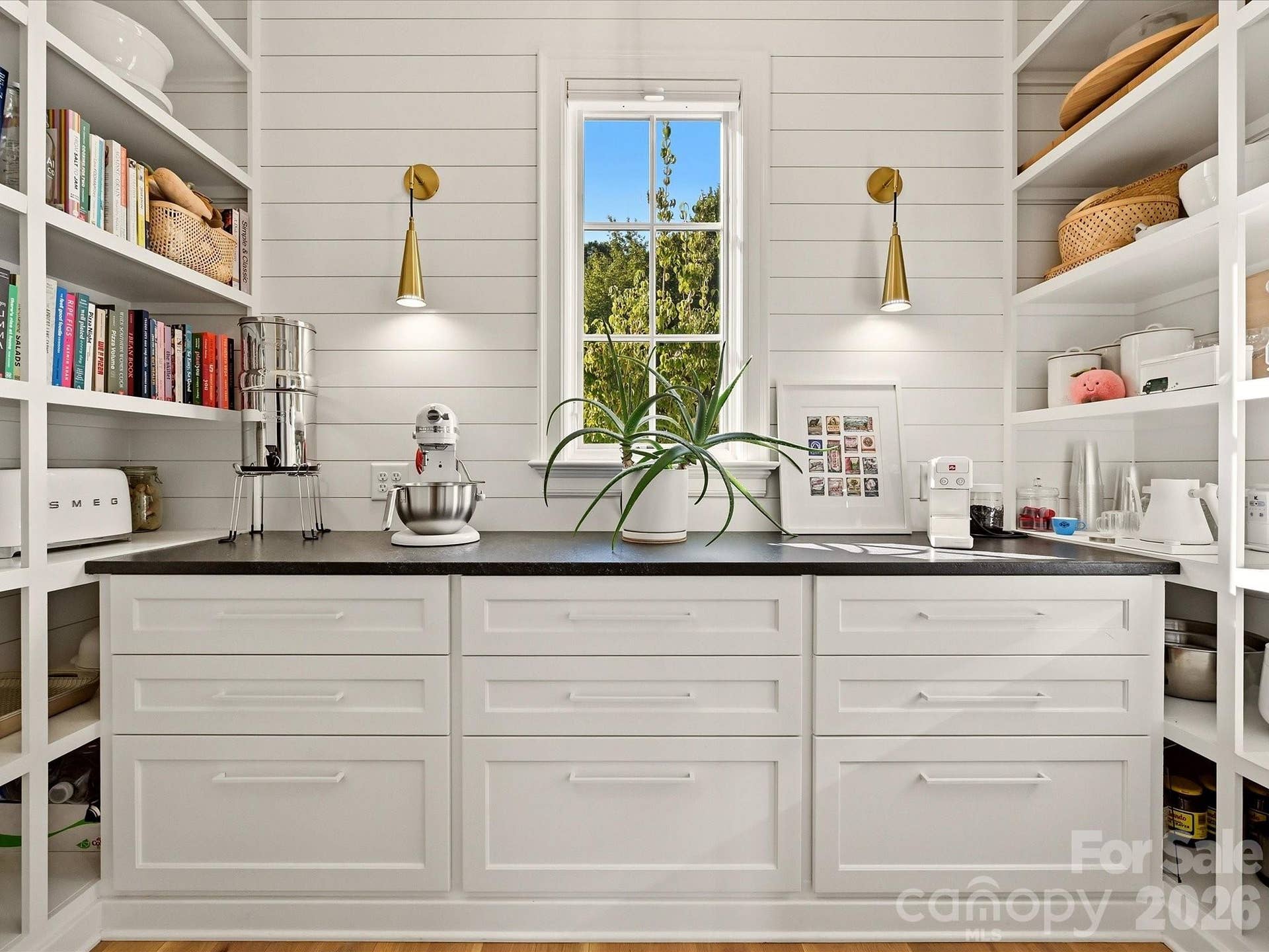 Spacious walk-in pantry offers abundant built-in shelving, generous counter space, and extensive storage designed to keep everyday essentials beautifully organized.