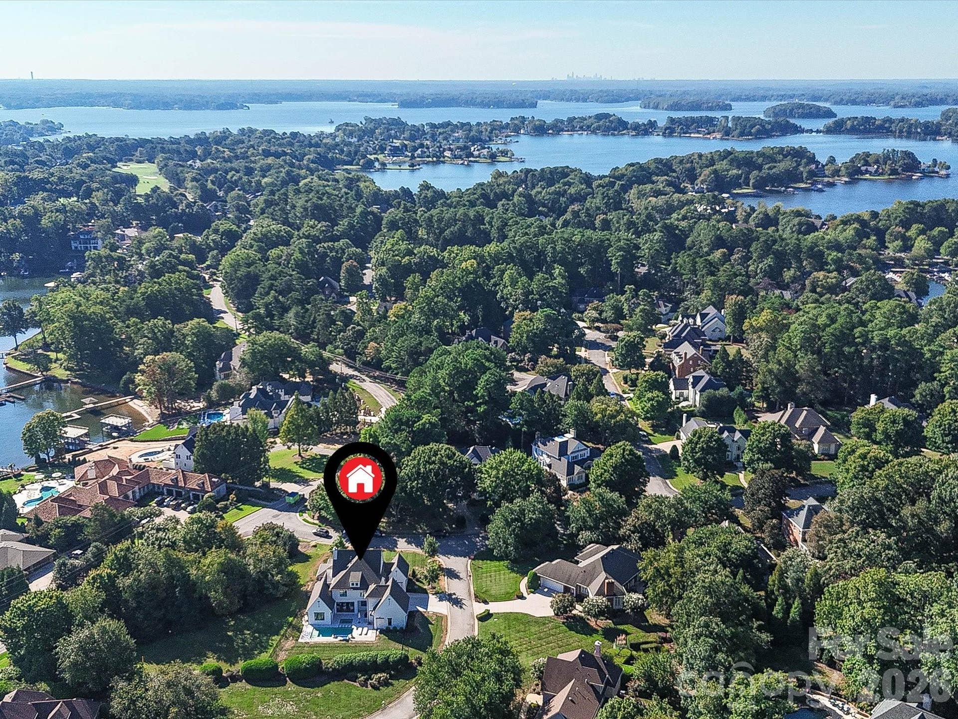 Aerial view highlights the homes desirable setting within a picturesque Lake Norman community, surrounded by mature trees and convenient access to the water.