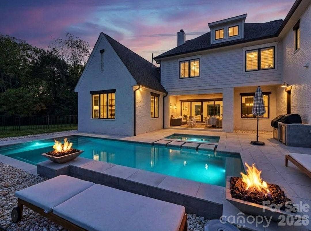 Resort-style outdoor living takes center stage with a sparkling private pool, integrated spa, fire features, and covered patio designed for relaxing or entertaining after sunset.