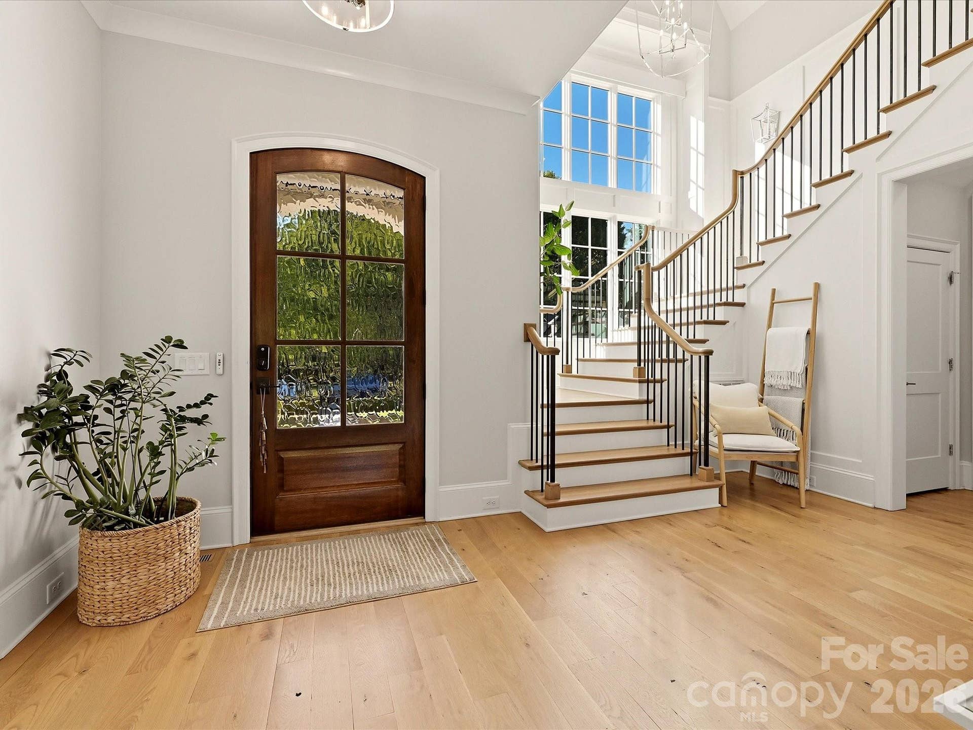 A welcoming foyer showcases light-filled interiors, warm hardwood floors, and a beautifully crafted staircase that creates an impressive first impression.